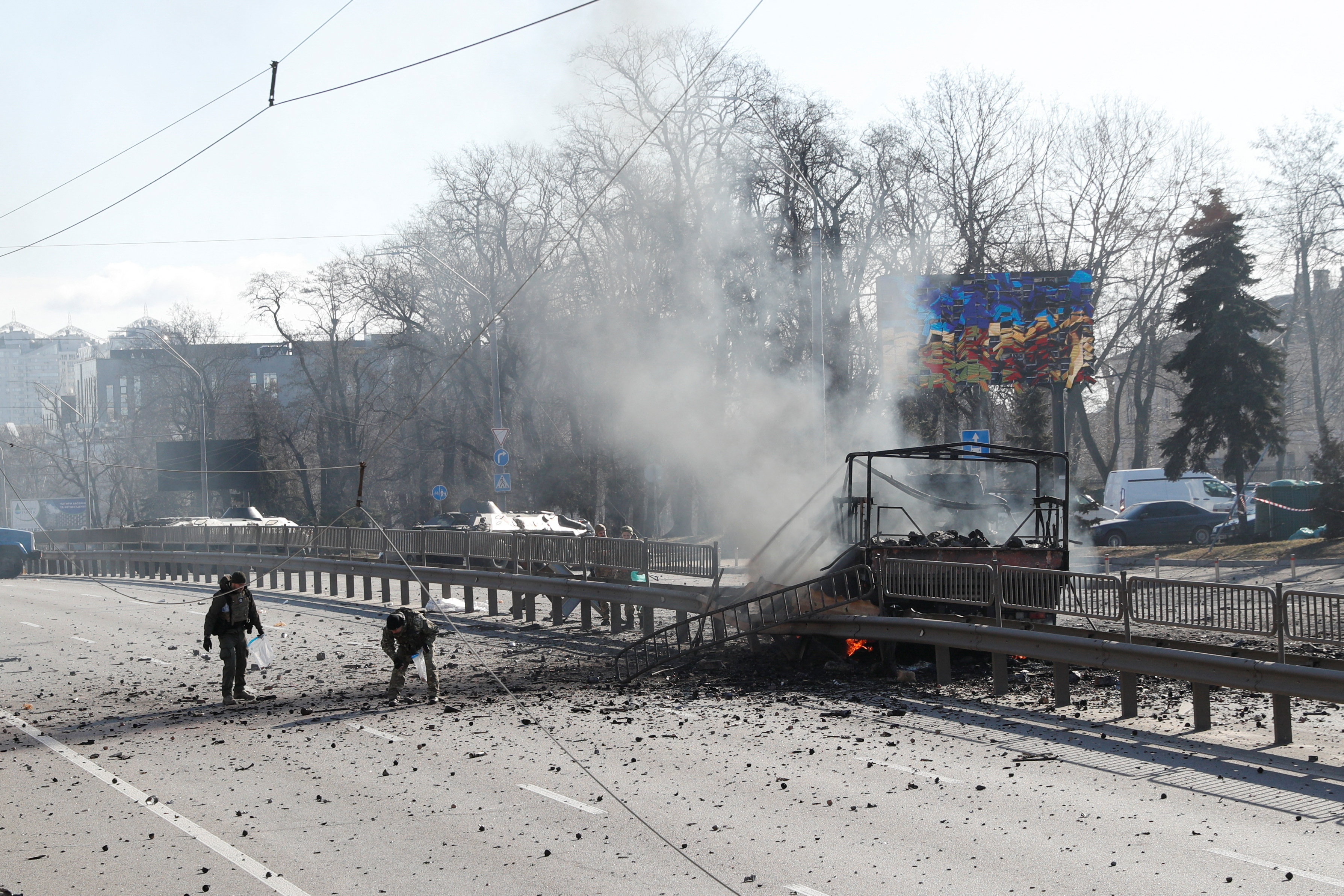 Ukrainian servicemen inspect near a damaged vehicle, at the site of a fighting with Russian