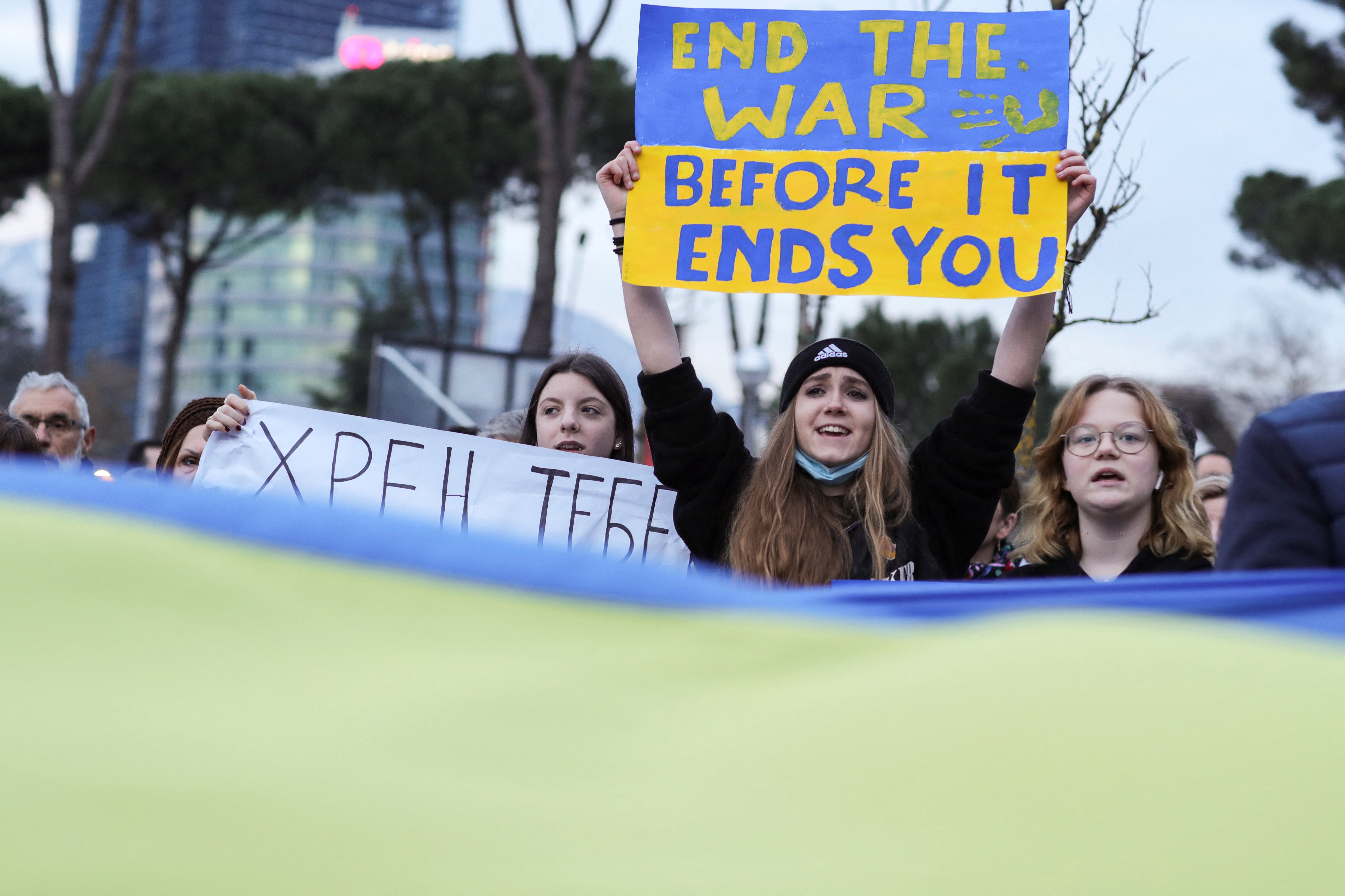 People hold placards during an anti-war protest, after Russia launched a massive military operation against Ukraine, in Tirana