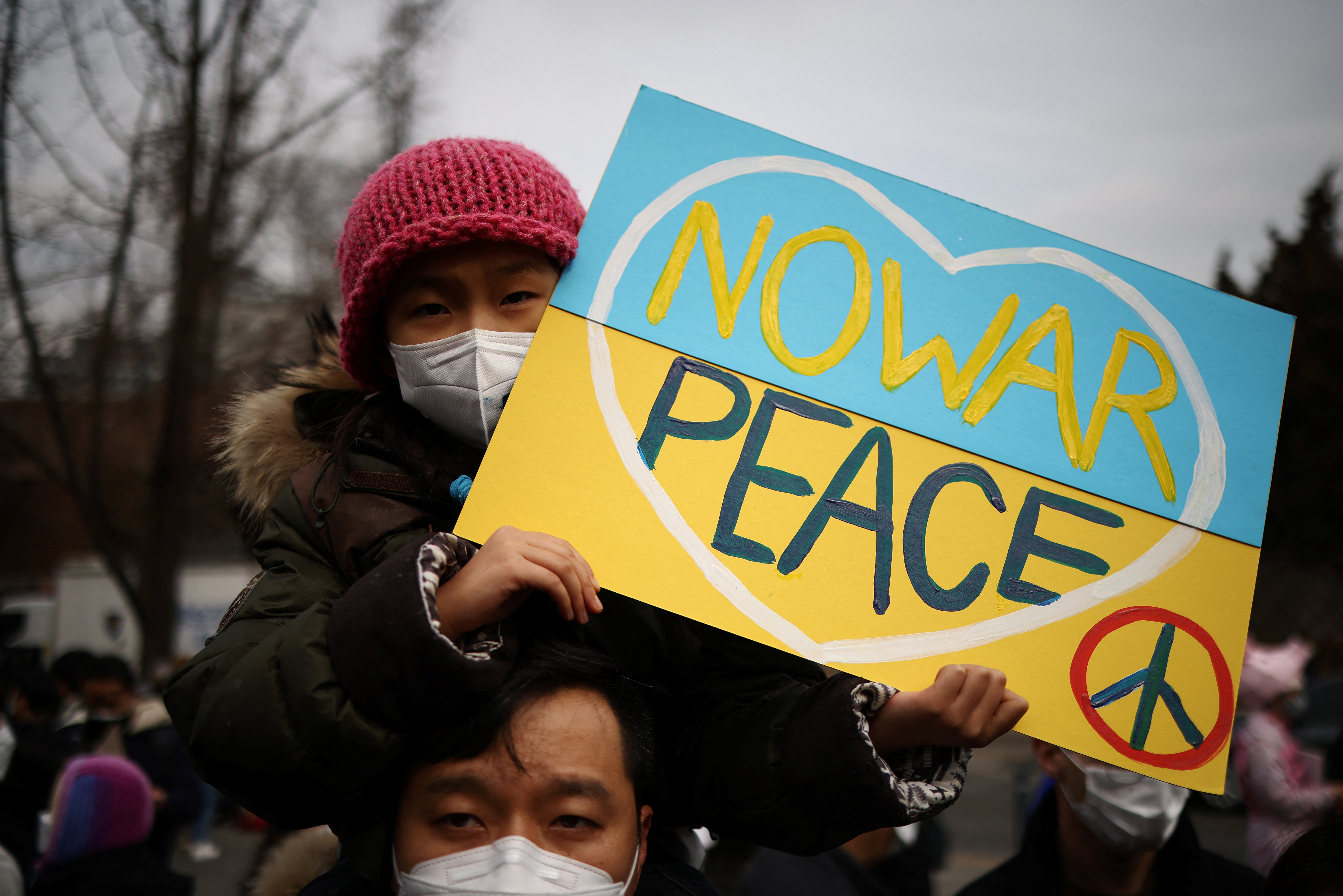 A father and his daughter attend a protest against the massive military operation by Russia against Ukraine, near the Russian embassy in Seoul, South Korea
