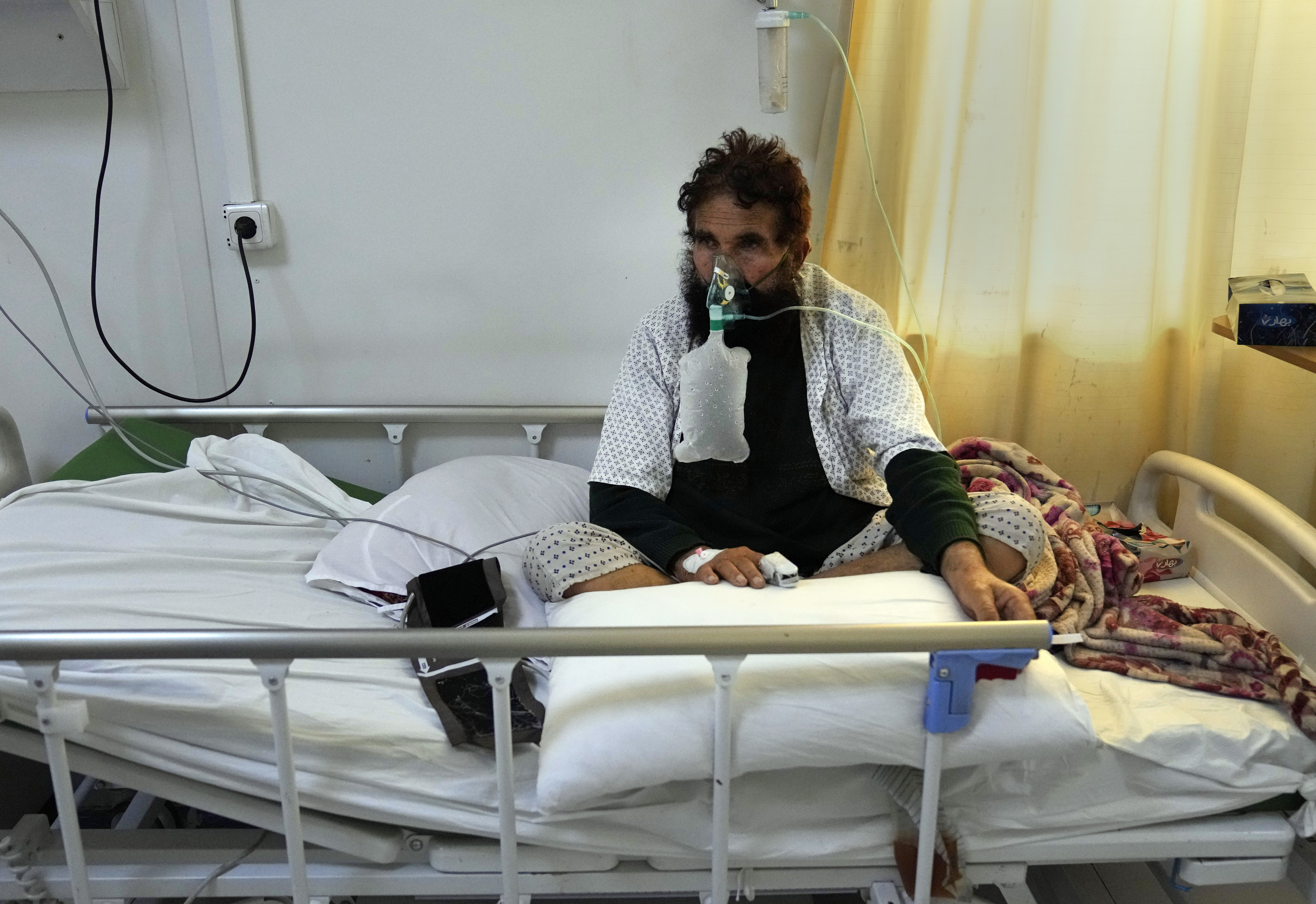 An Afghan patient who infected with COVID-19 sits on a bed in the intensive care unit