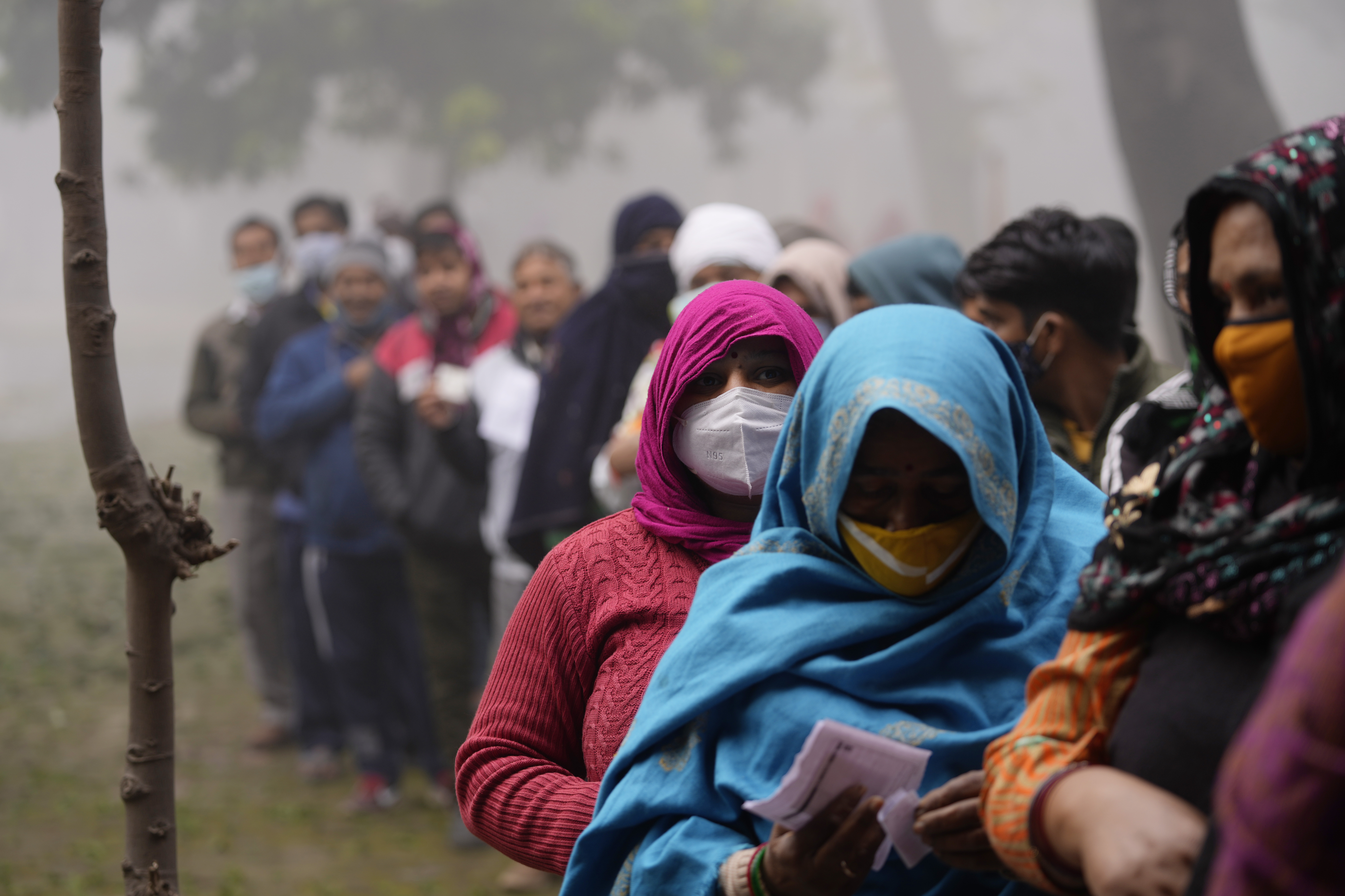 People line up to vote during the first phase of the Uttar Pradesh state elections at a village near Ghaziabad, India