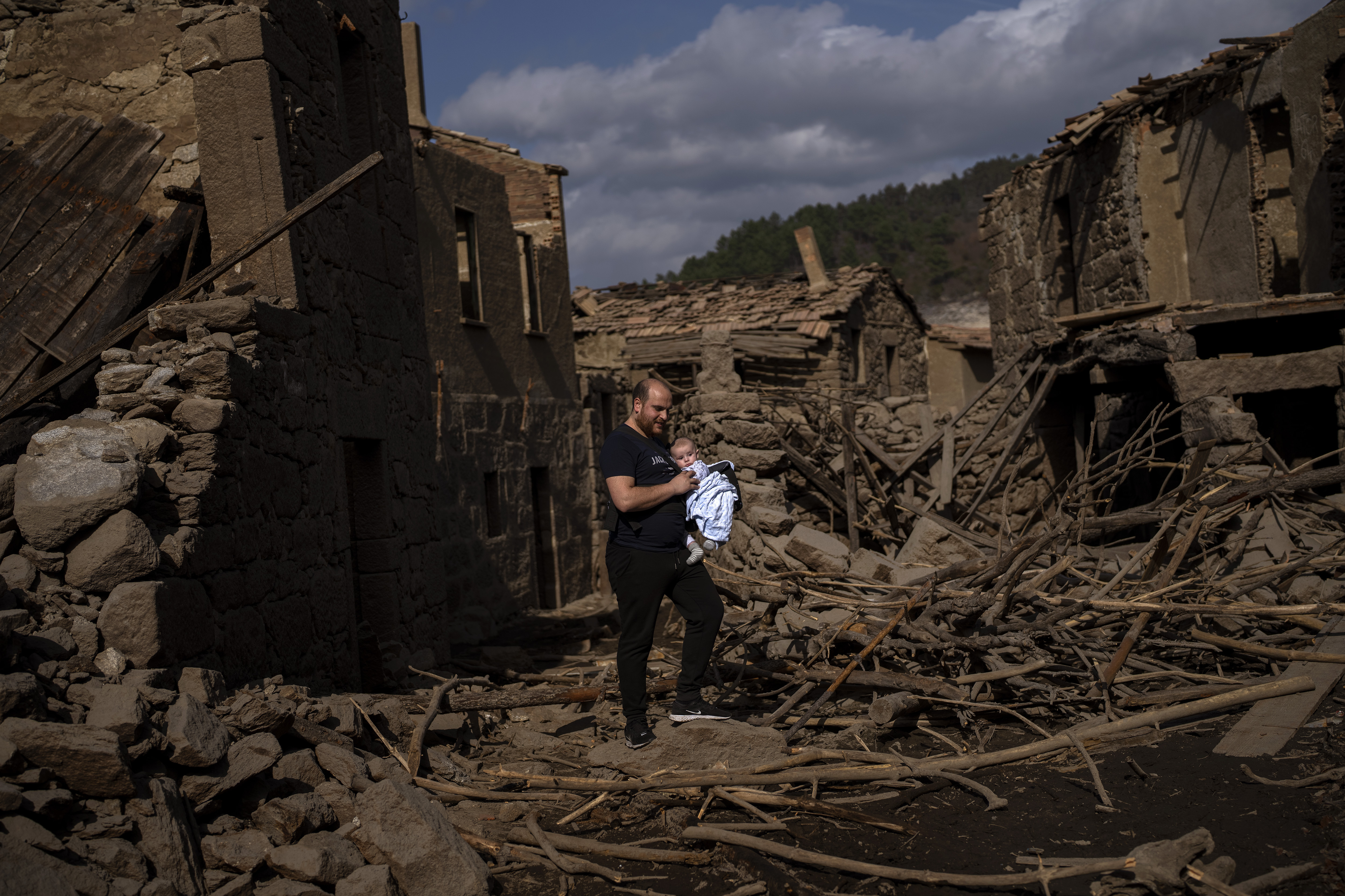 Rafael Monlina, 33, holds his four-month-old son Marcos as they visit the old village of Aceredo