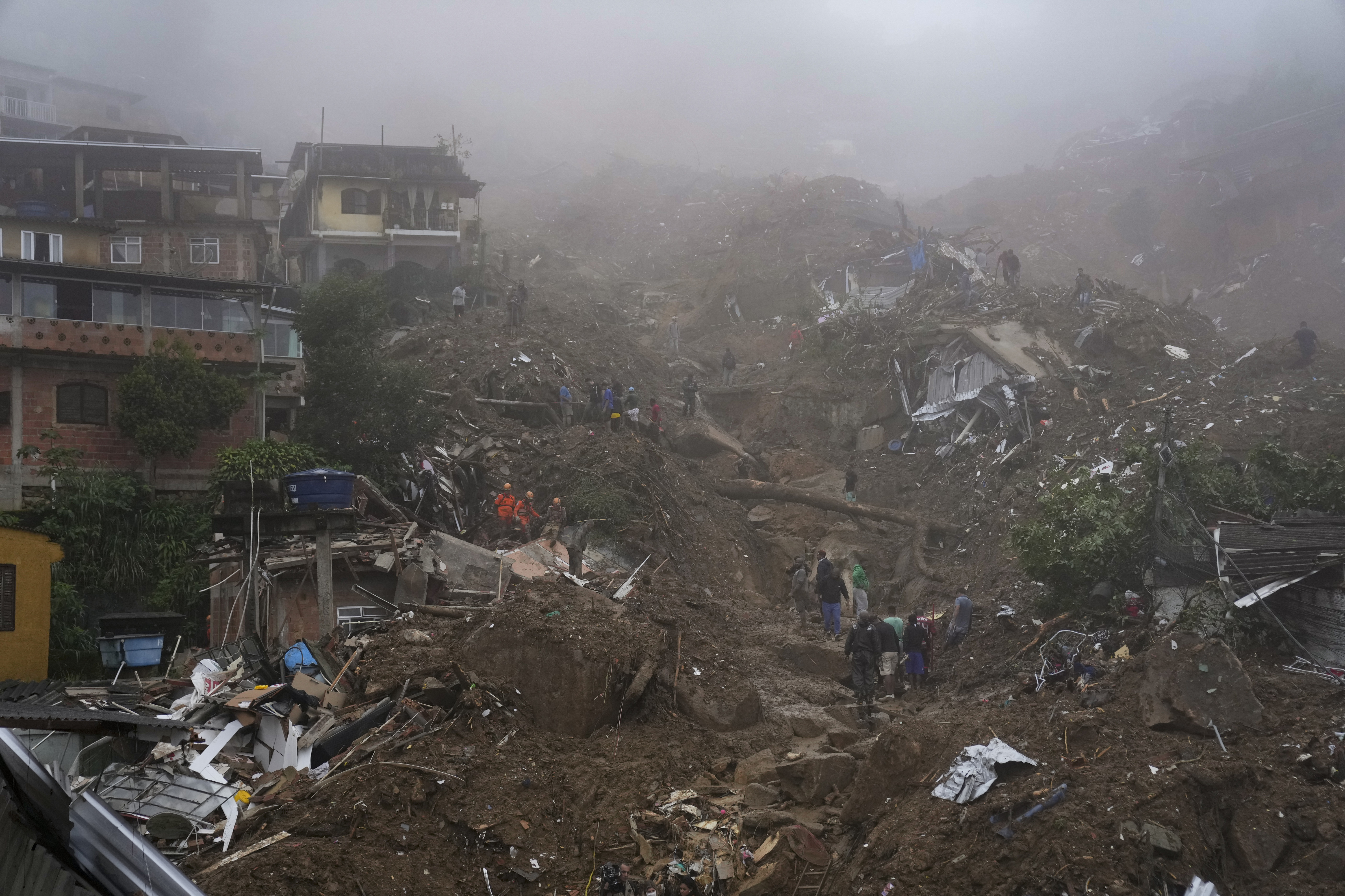 Rescue workers and residents look for victims in an area damaged by landslides in Petropolis