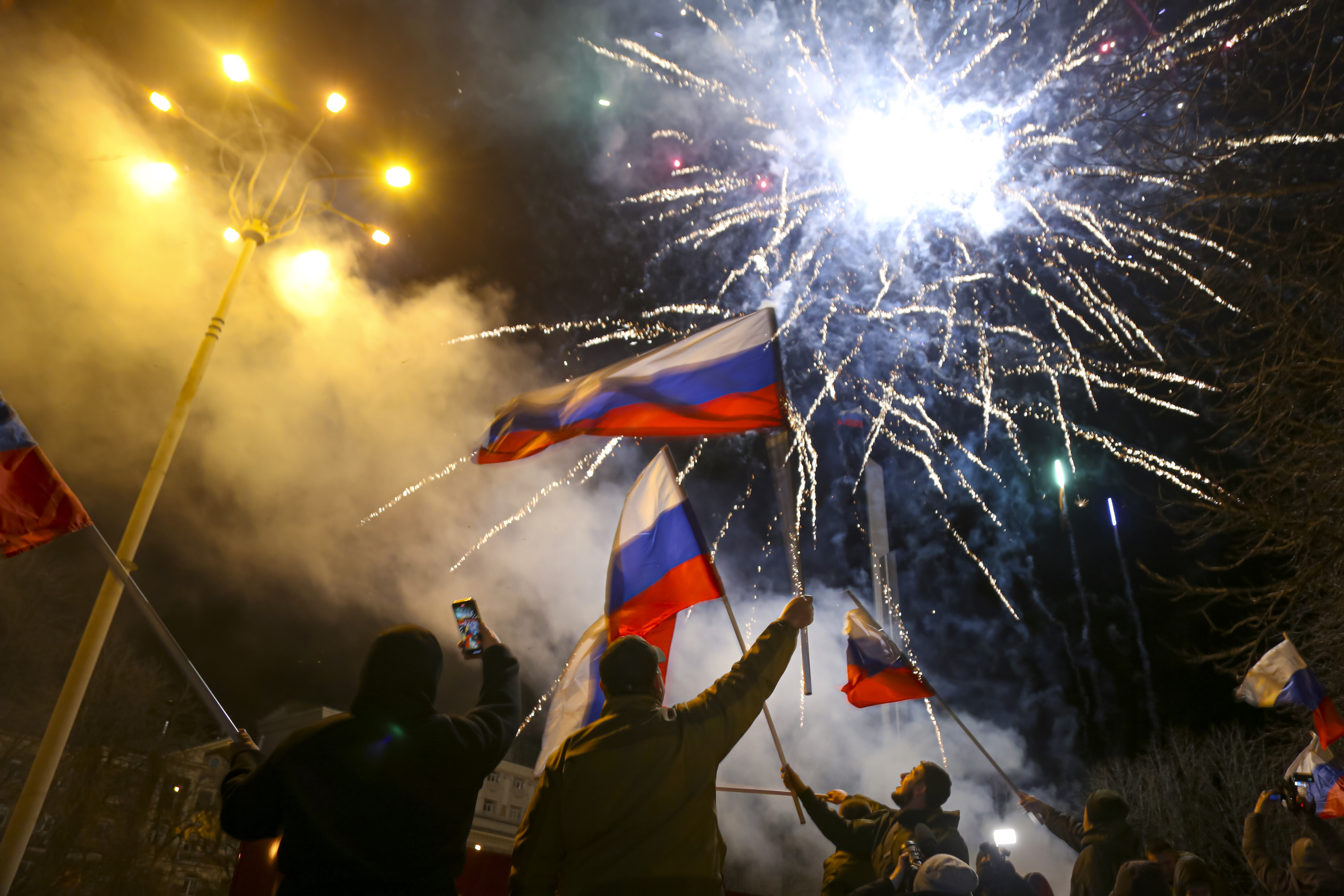 People wave Russian national flags celebrating the recognizing the independence in the center of Donetsk