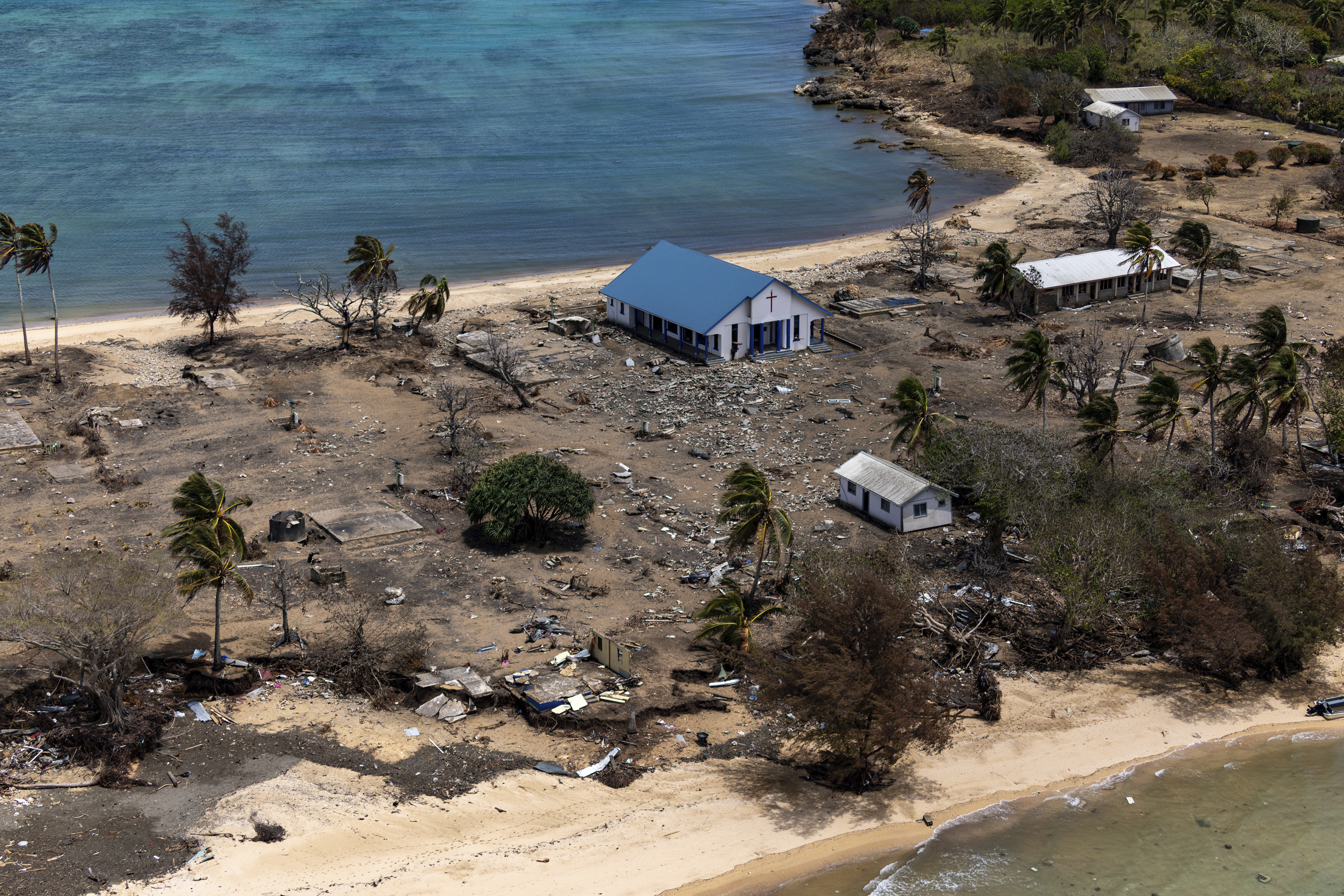 ebris from damaged building and trees are strewn around on Atata Island in Tonga, on Jan. 28, 2022, after a massive volcanic eruption and tsunami