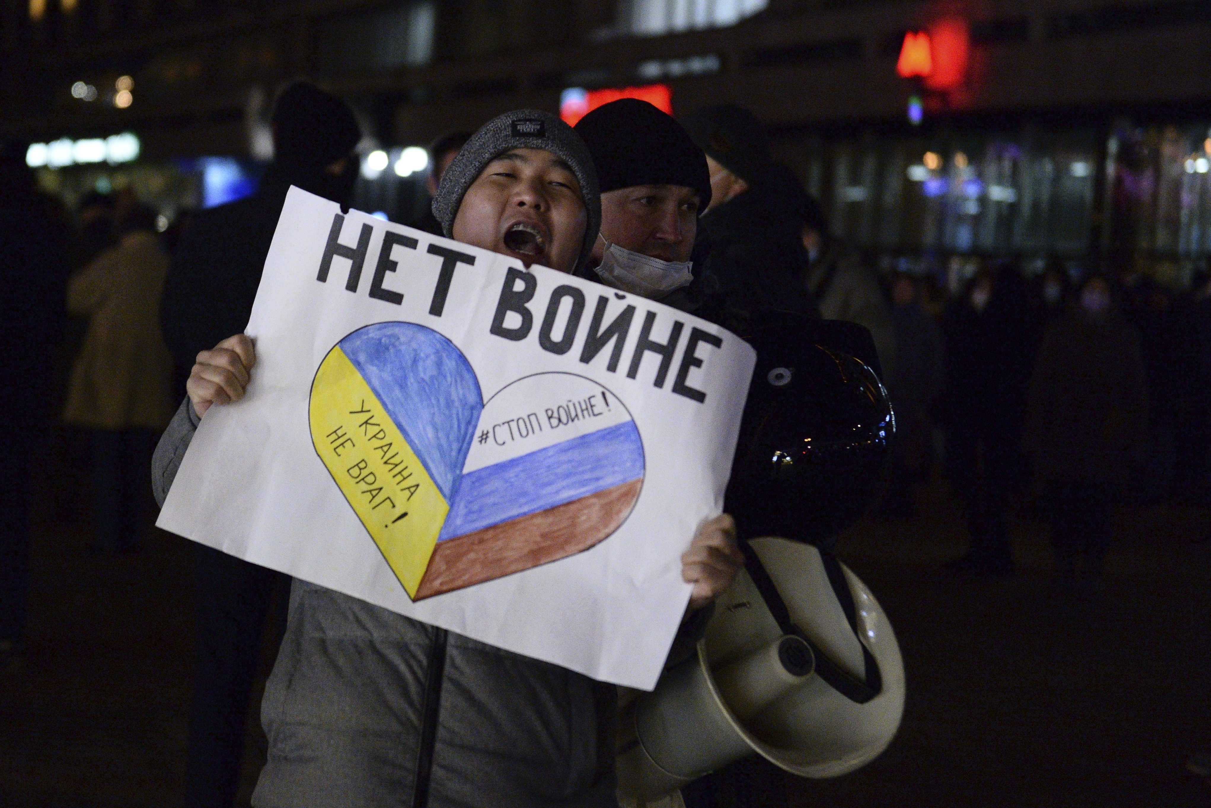 A protester in Russia carrying a sign that reads "no war" is seen as he gets detained by the police