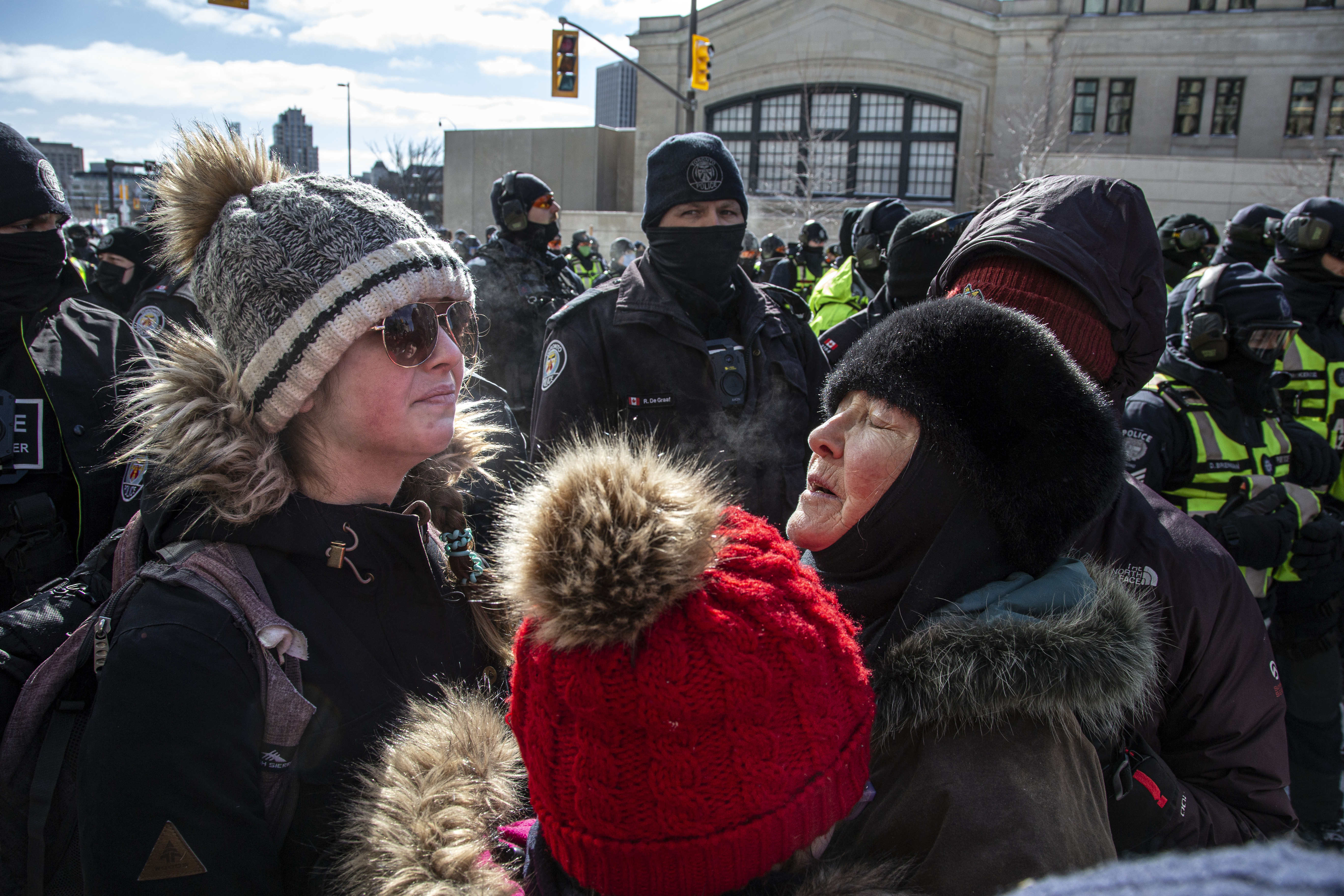 Protesters huddle together in front of a police line in Ottawa