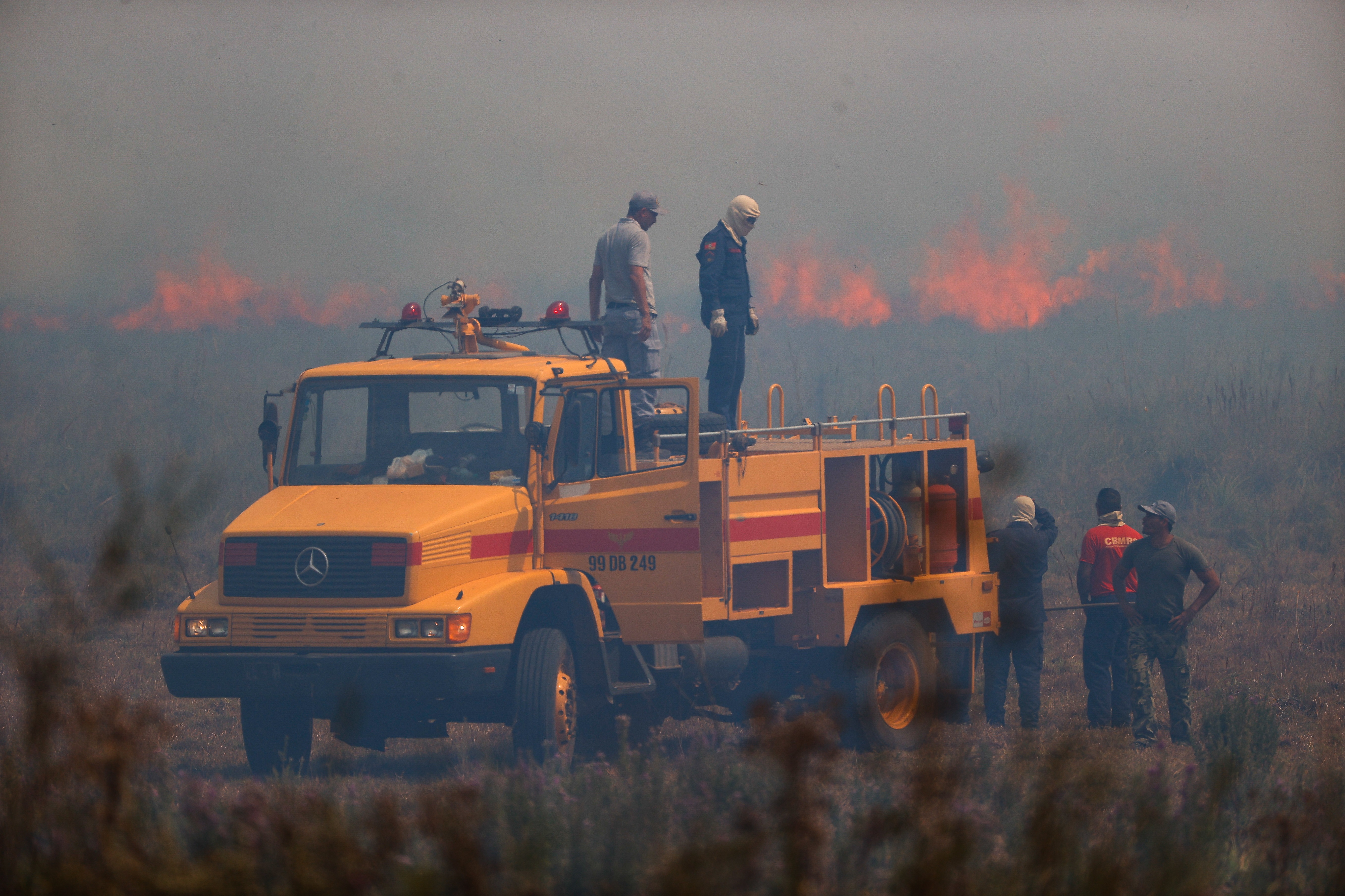 Firefighters work to put out a fire in the town of Santo Tome