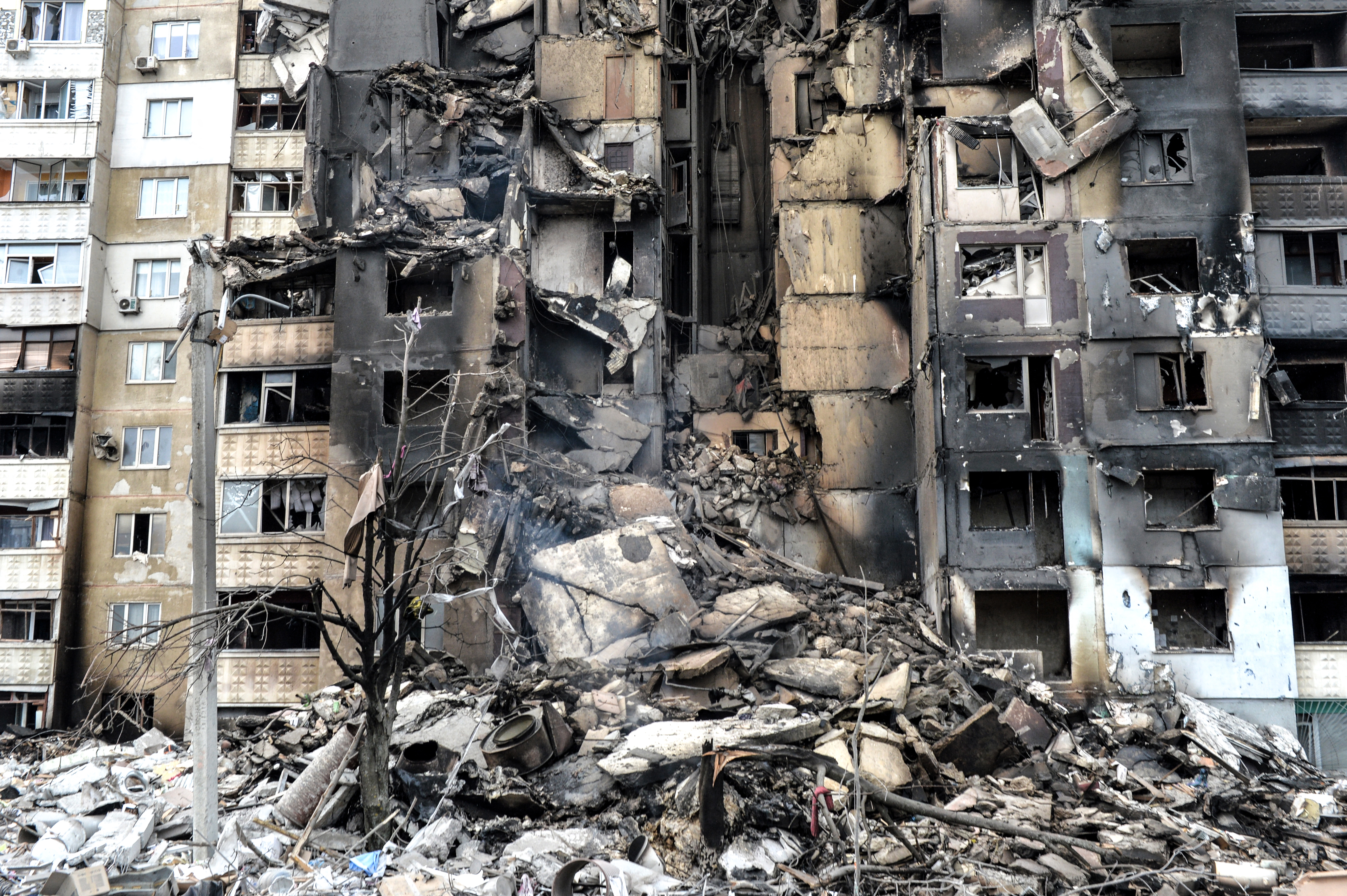 This picture shows an apartment building destroyed after shelling the day before in Ukraine's second-biggest city of Kharkiv on March 8, 2022. - The number of people fleeing the war flooding across Ukraine's borders to escape towns devastated by shelling and air strikes passed two million, in Europe's fastest-growing refugee crisis since World War II, according to the United Nations. 