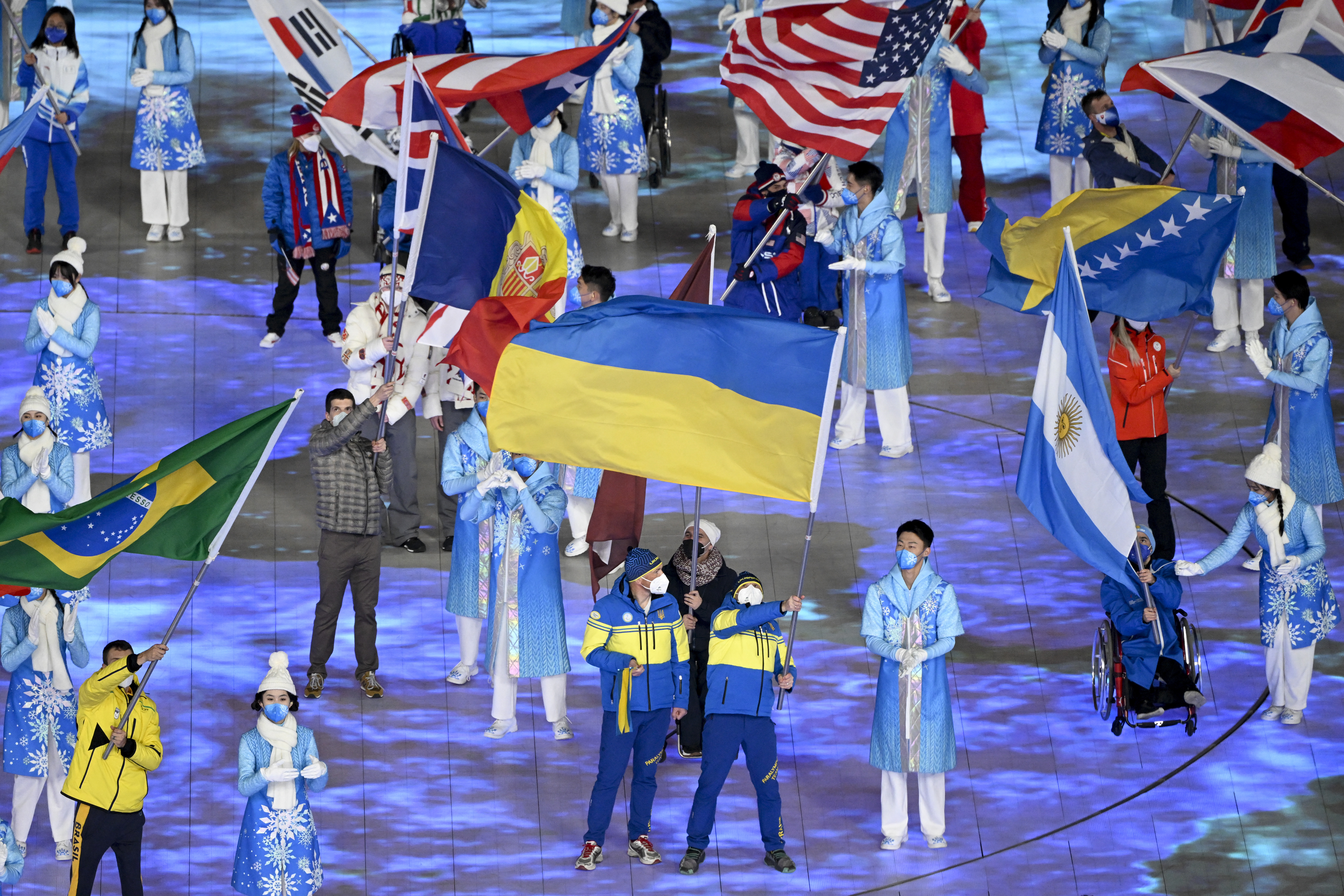 Flagbearer Ukraine's Vitalii Lukianenko (R) takes part in the closing ceremony of the Beijing 2022 Winter Paralympic Games at the National Stadium, known as the Bird's Nest, in Beijing