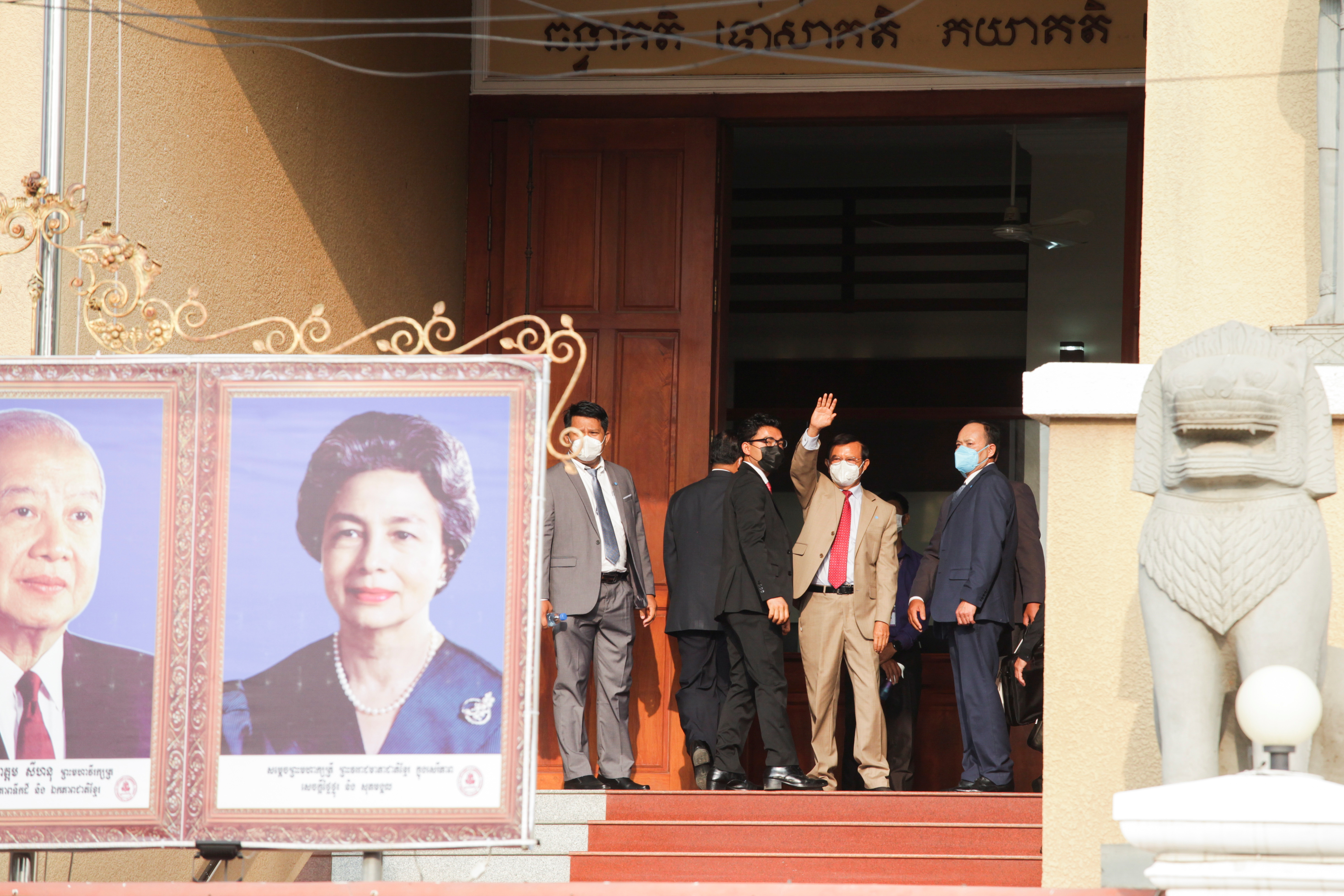 opposition leader Kem Sokha stands at the door of a court in Phnom Penh to wave to supporters as his trial for alleged treason resumed in January