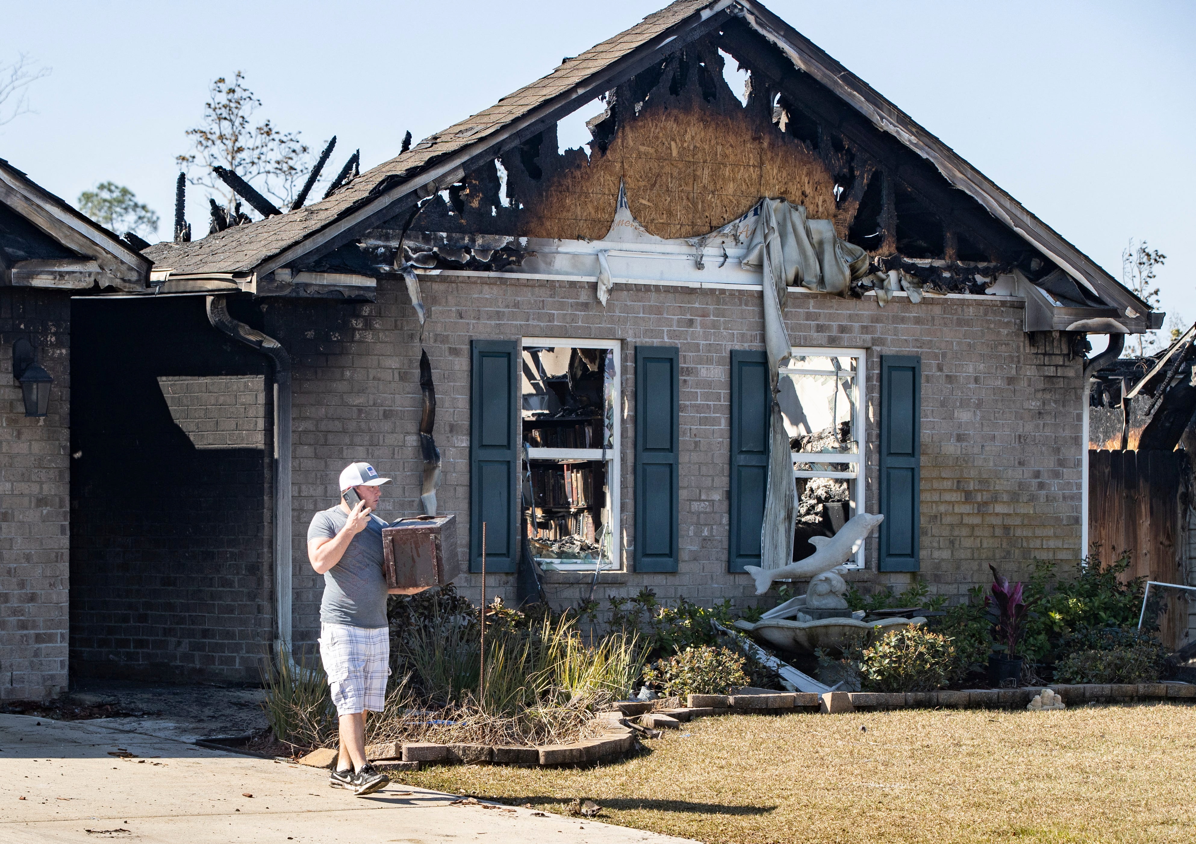Person standing in front of scorched home