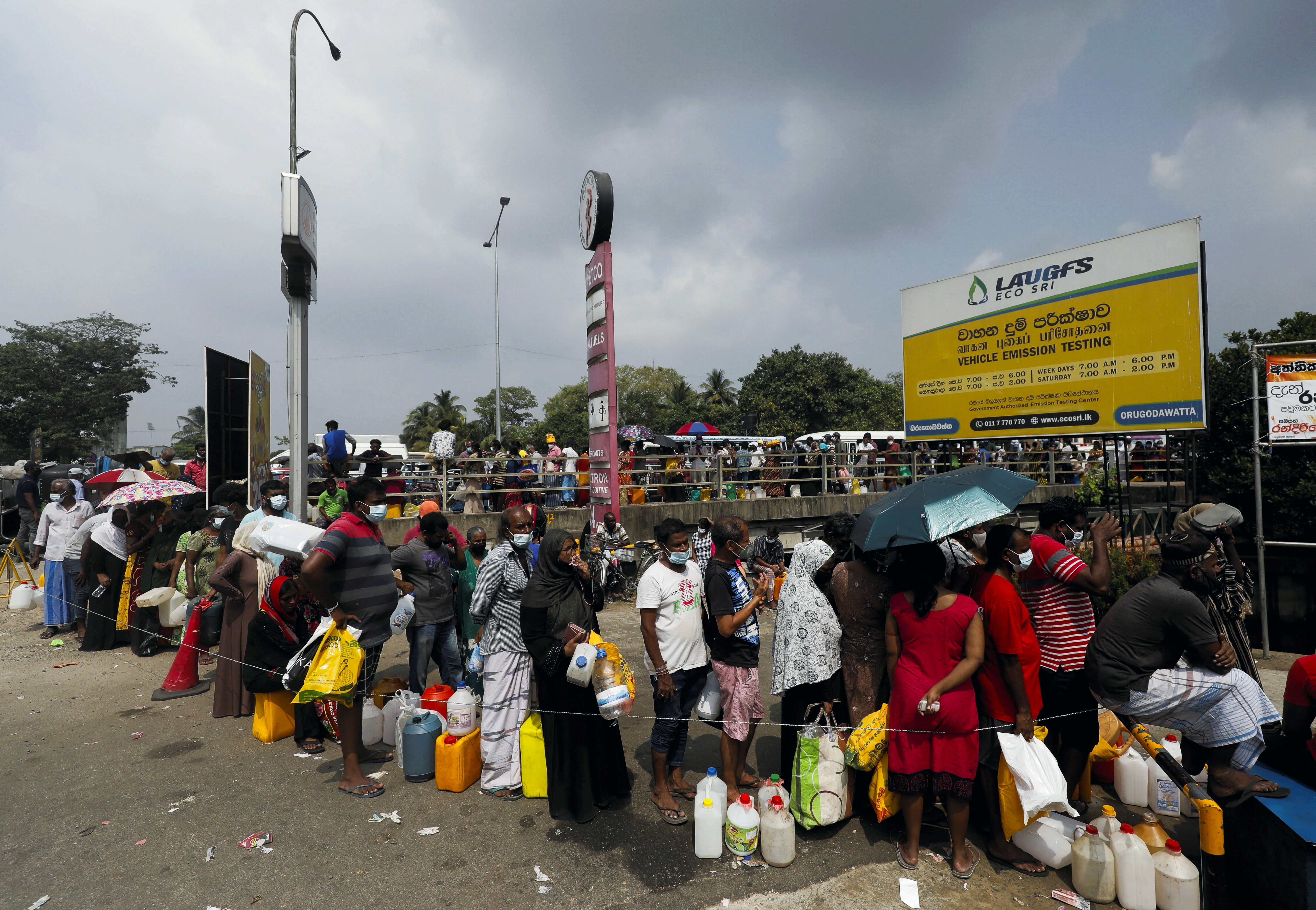 People stand in a long queue to buy kerosene