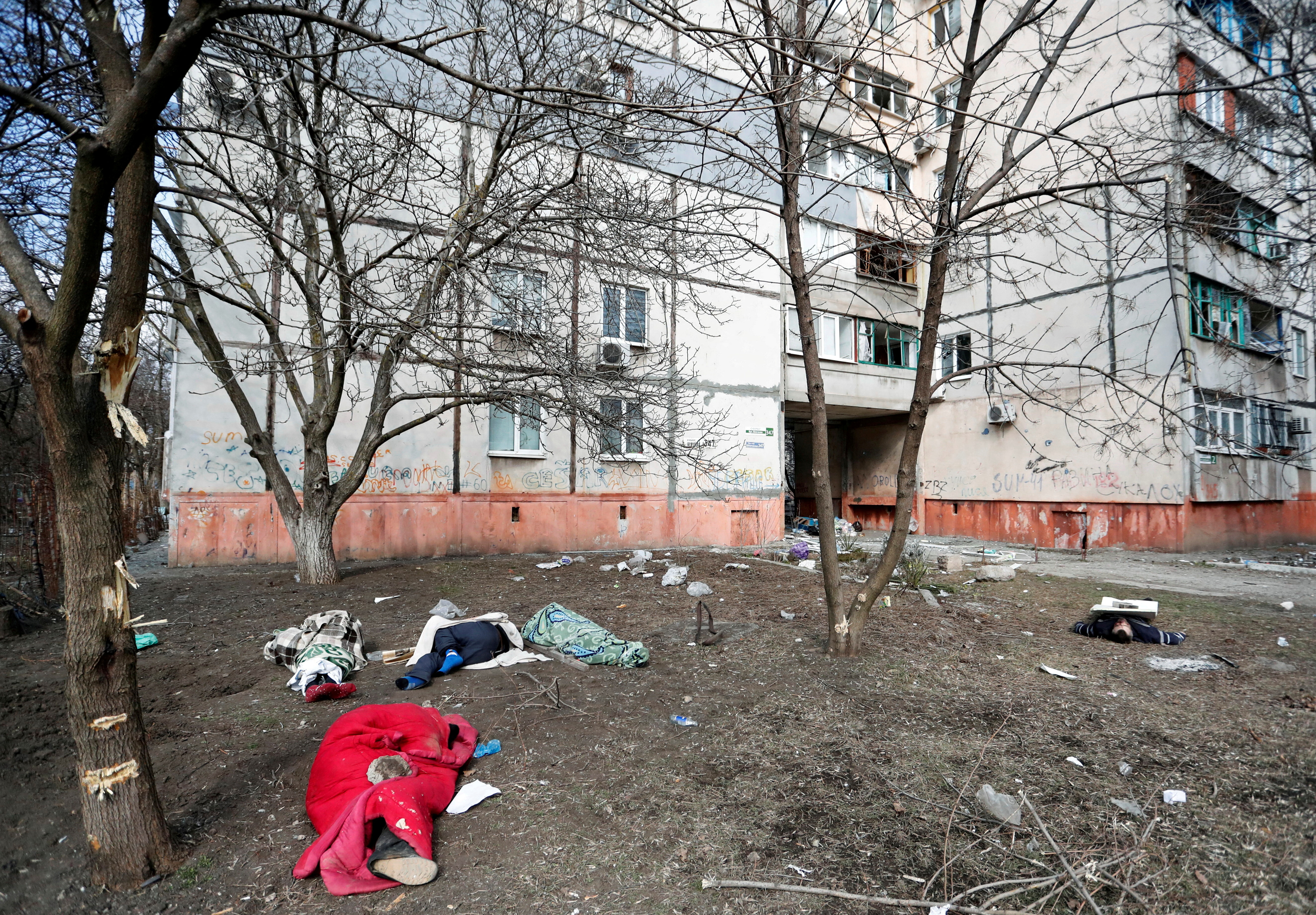 Bodies of people killed during Ukraine-Russia conflict lie on the ground next to a residential building in the besieged southern port city of Mariupol, Ukraine March 18, 2022.