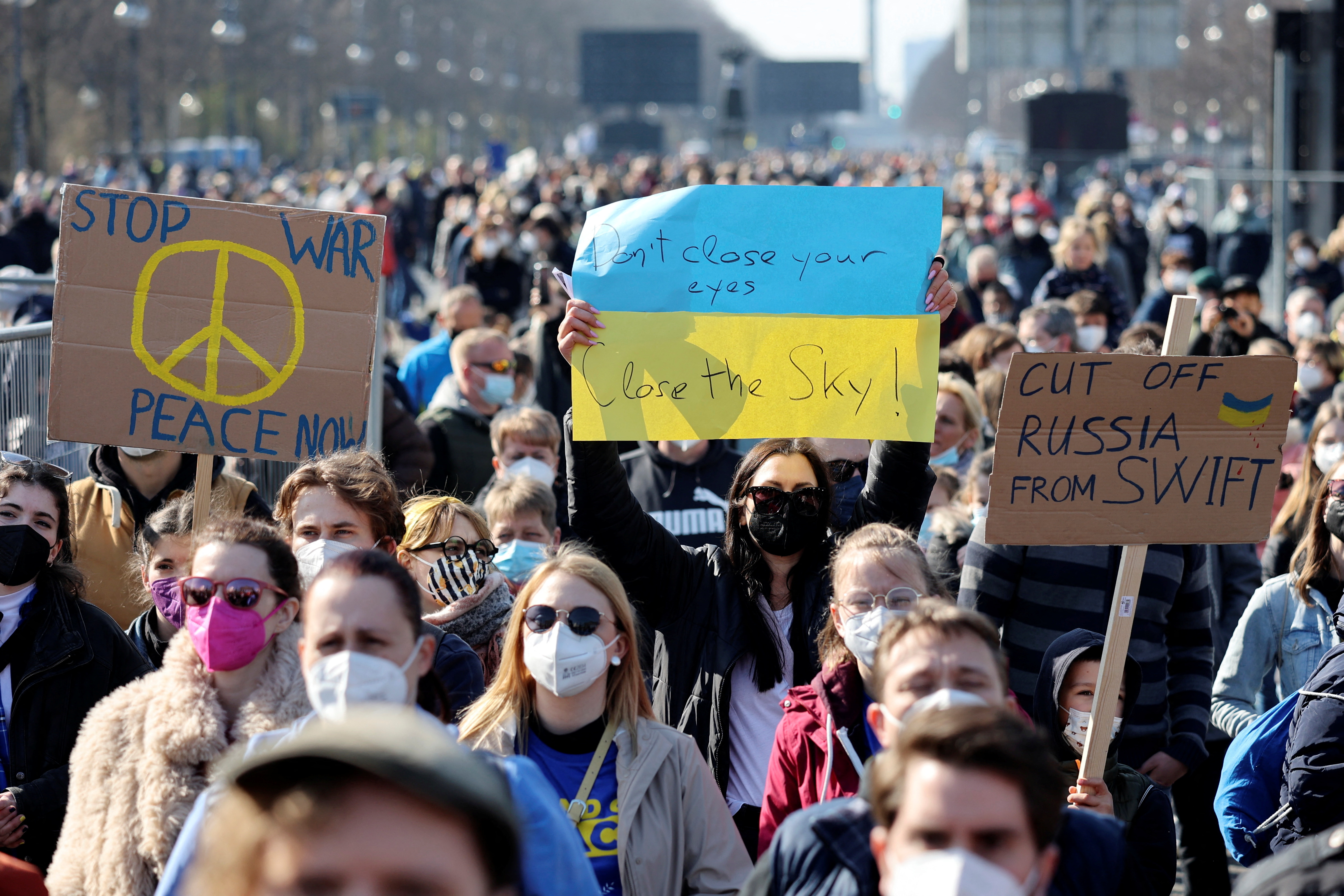People hold signs at the anti-war concert "Sound for Peace". 