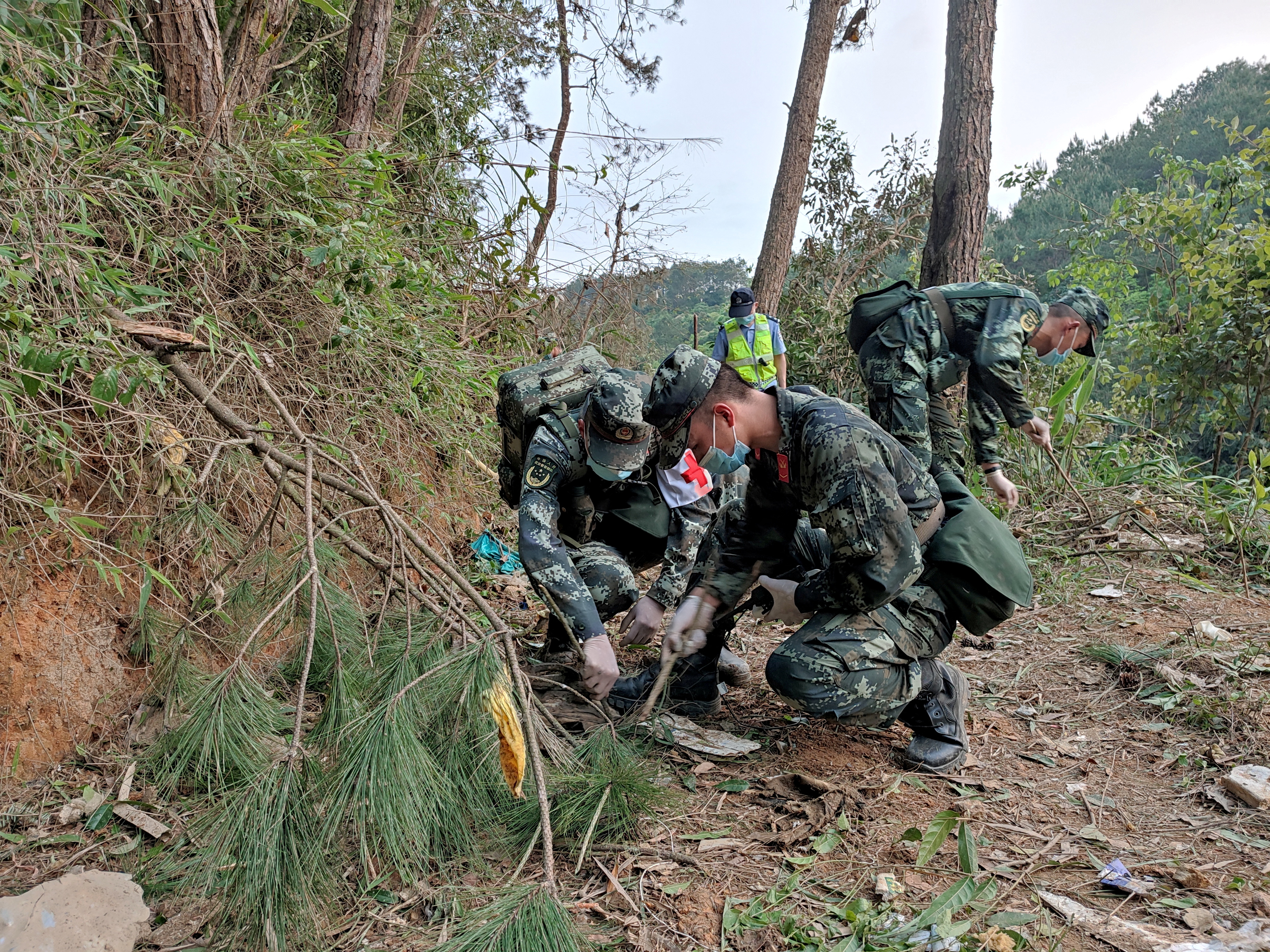 Paramilitary police officers work on the hillside where a China Eastern plane crashed on Momday