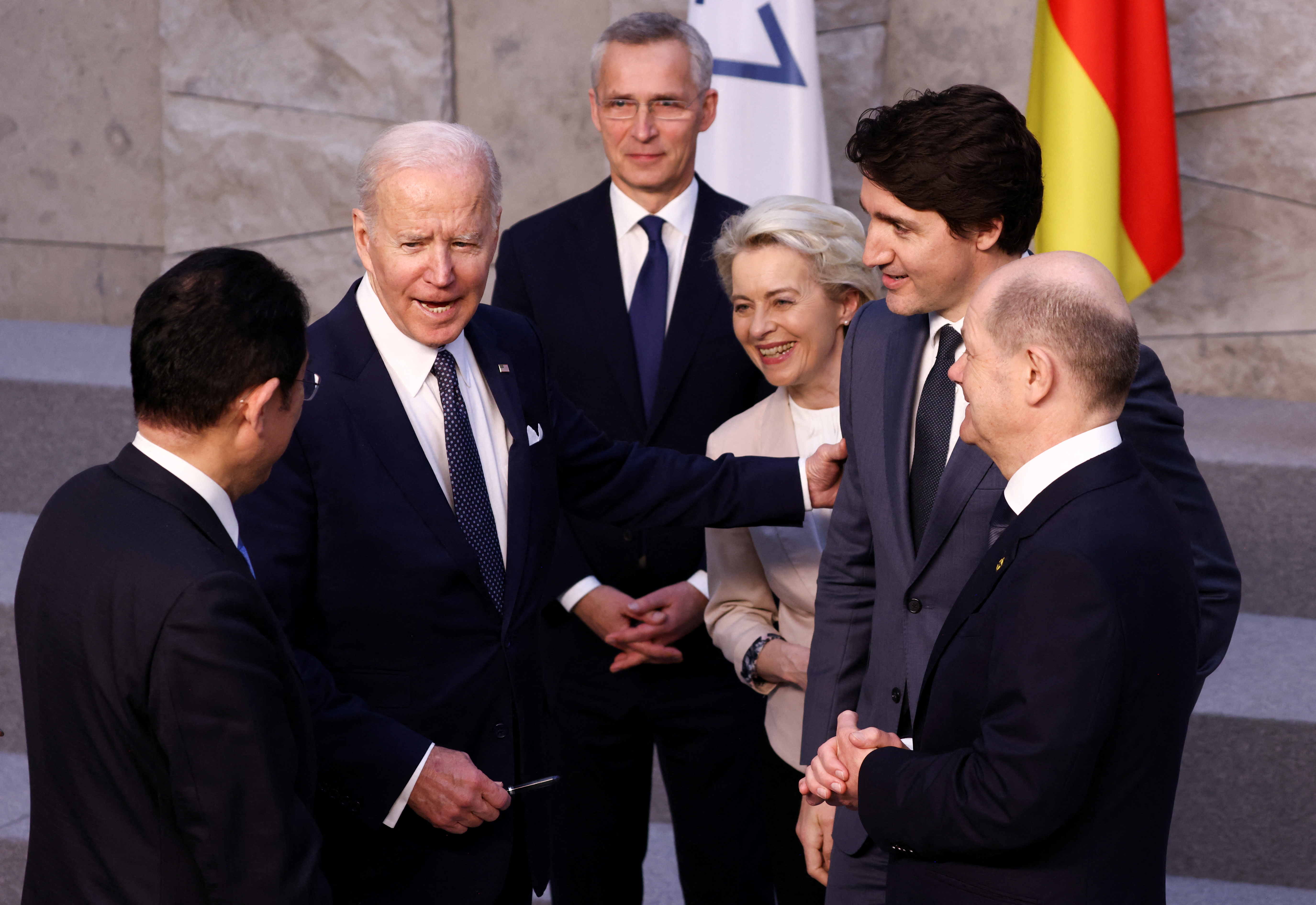 U.S. President Joe Biden speaks with Japan's Prime Minister Fumio Kishida, Germany's Chancellor Olaf Scholz, Canada's Prime Minister Justin Trudeau, European Commission President Ursula von der Leyen and NATO Secretary-General Jens Stoltenberg before a G7 leaders' family photo during a NATO summit on Russia's invasion of Ukraine, at the alliance's headquarters in Brussels, Belgium