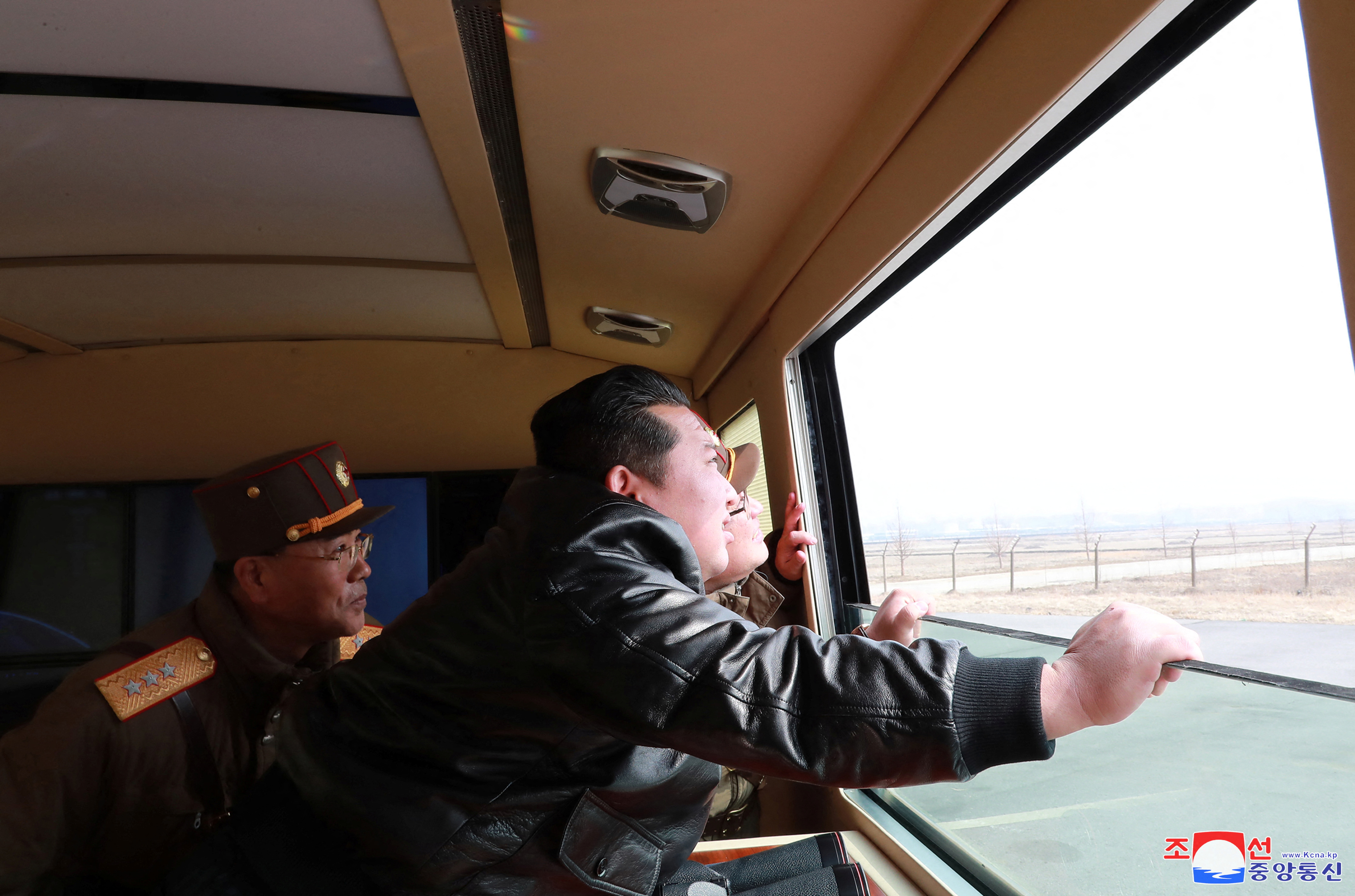 North Korean leader Kim Jong Un looks through a window during the test firing of what state media report is a "new type" of intercontinental ballistic missile