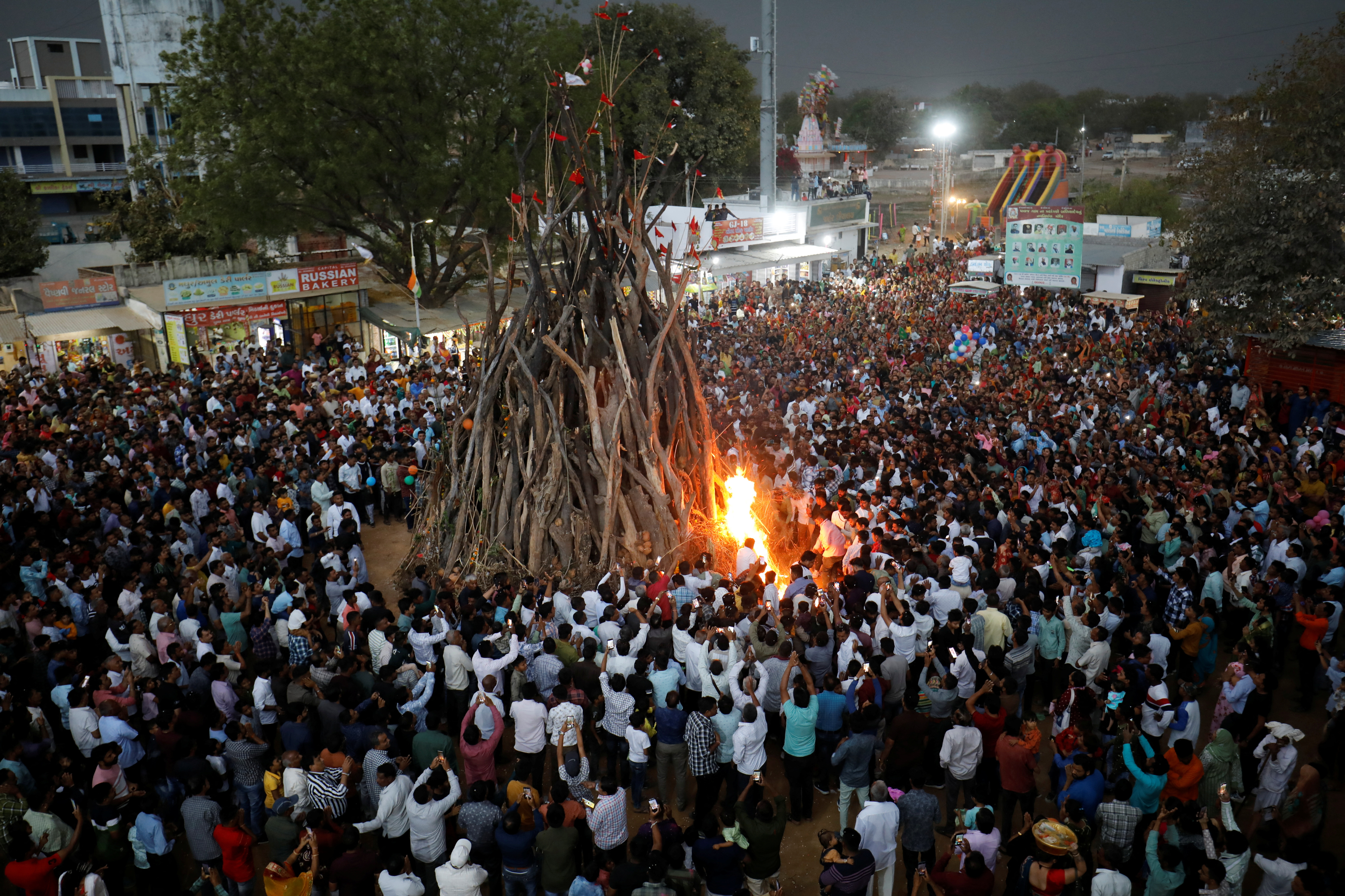 Hindu devotees create a bonfire during a ritual known as "Holika Dahan" which is part of the Holi festival celebrations on the outskirts of Ahmedabad, India