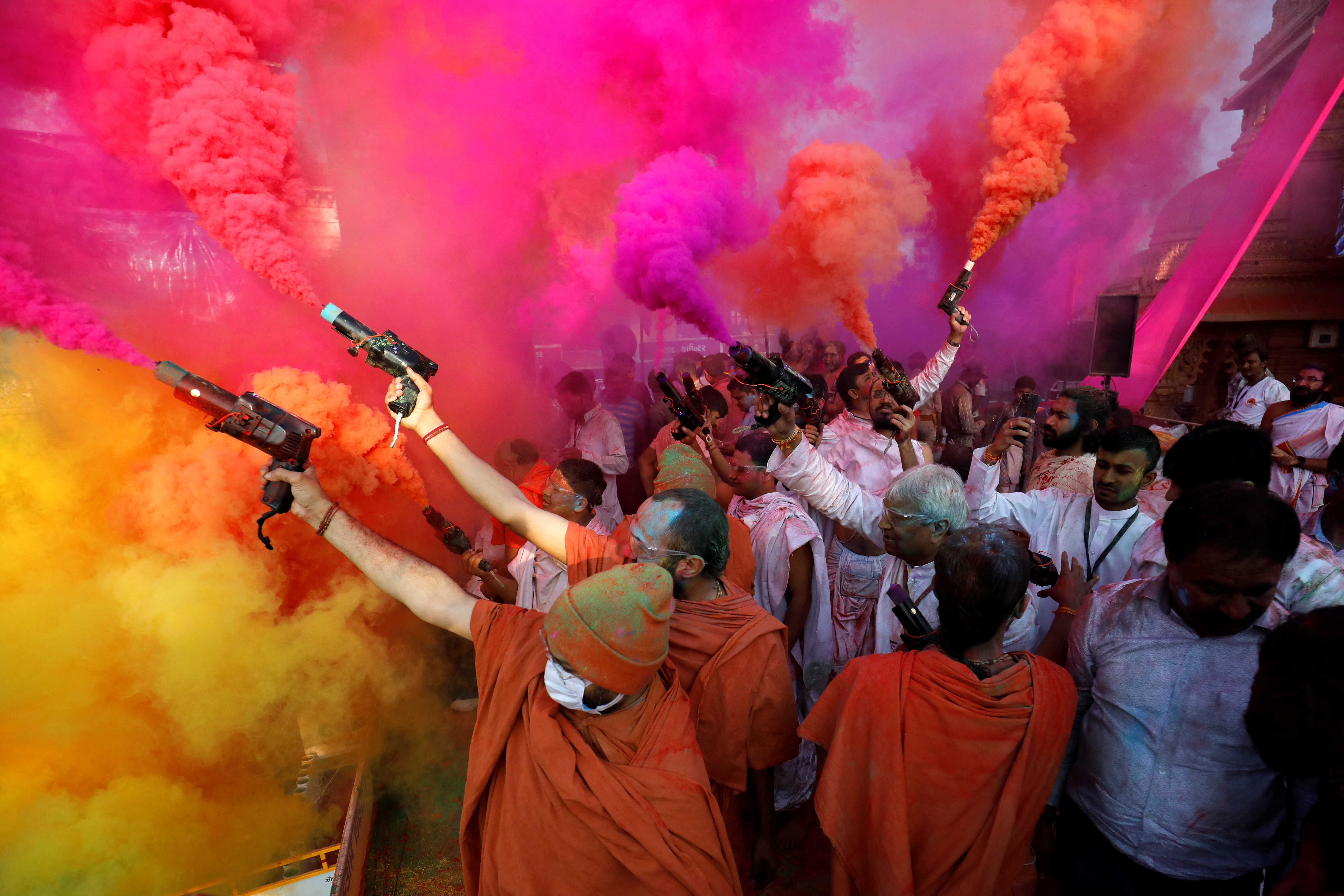 Hindu priests use colour smoke guns to celebrate Holi, the festival of colours, at a temple premises in Salangpur, in the western state of Gujarat, India