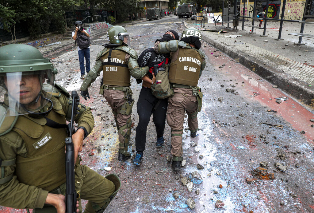 Armed Chilean police detain an anti-government protester in Santiago, Chile, in 2019.