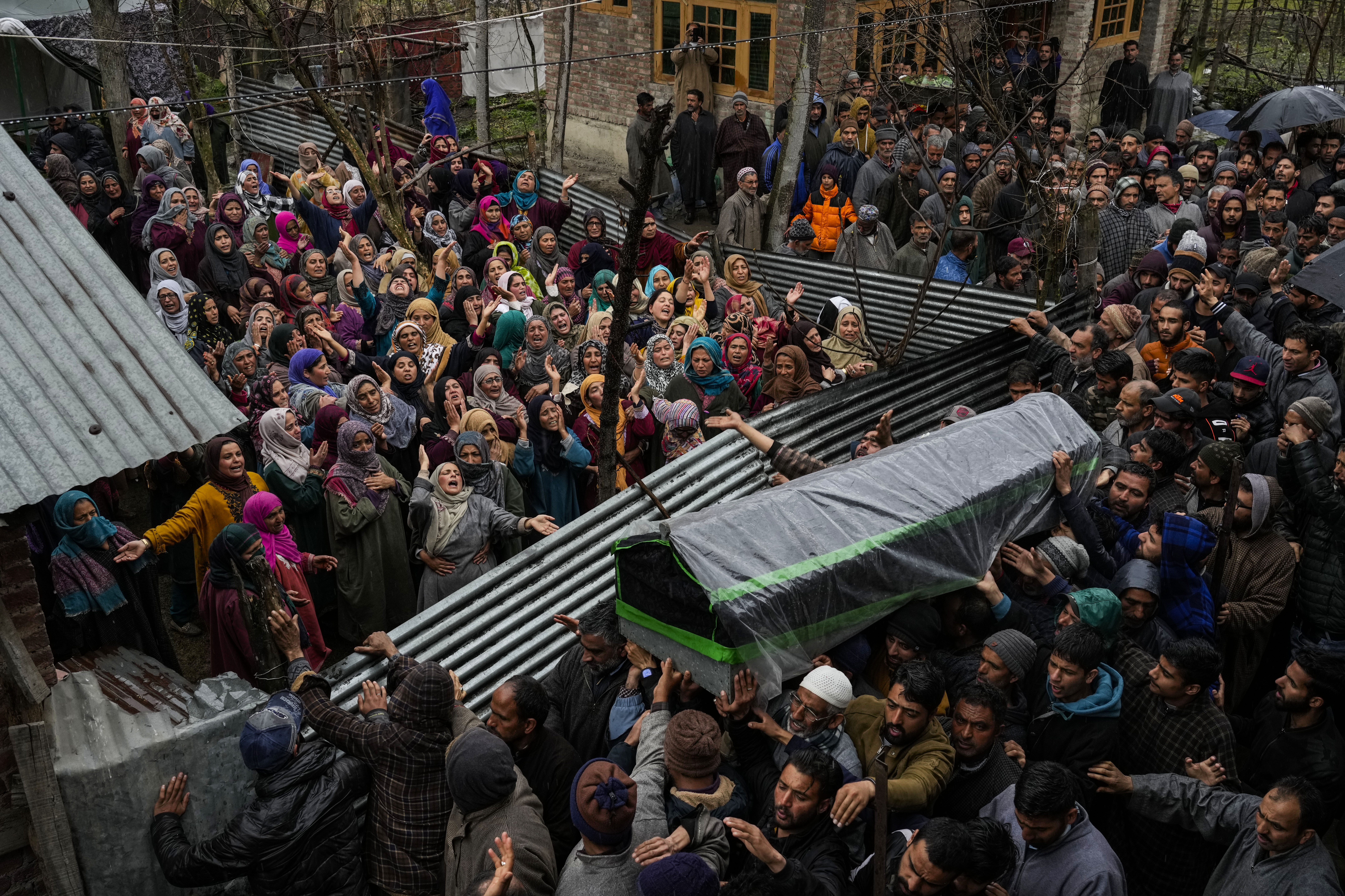 Family members and relatives mourn as they carry the body of Rafia Nazir, a young Kashmiri woman killed in grenade attack