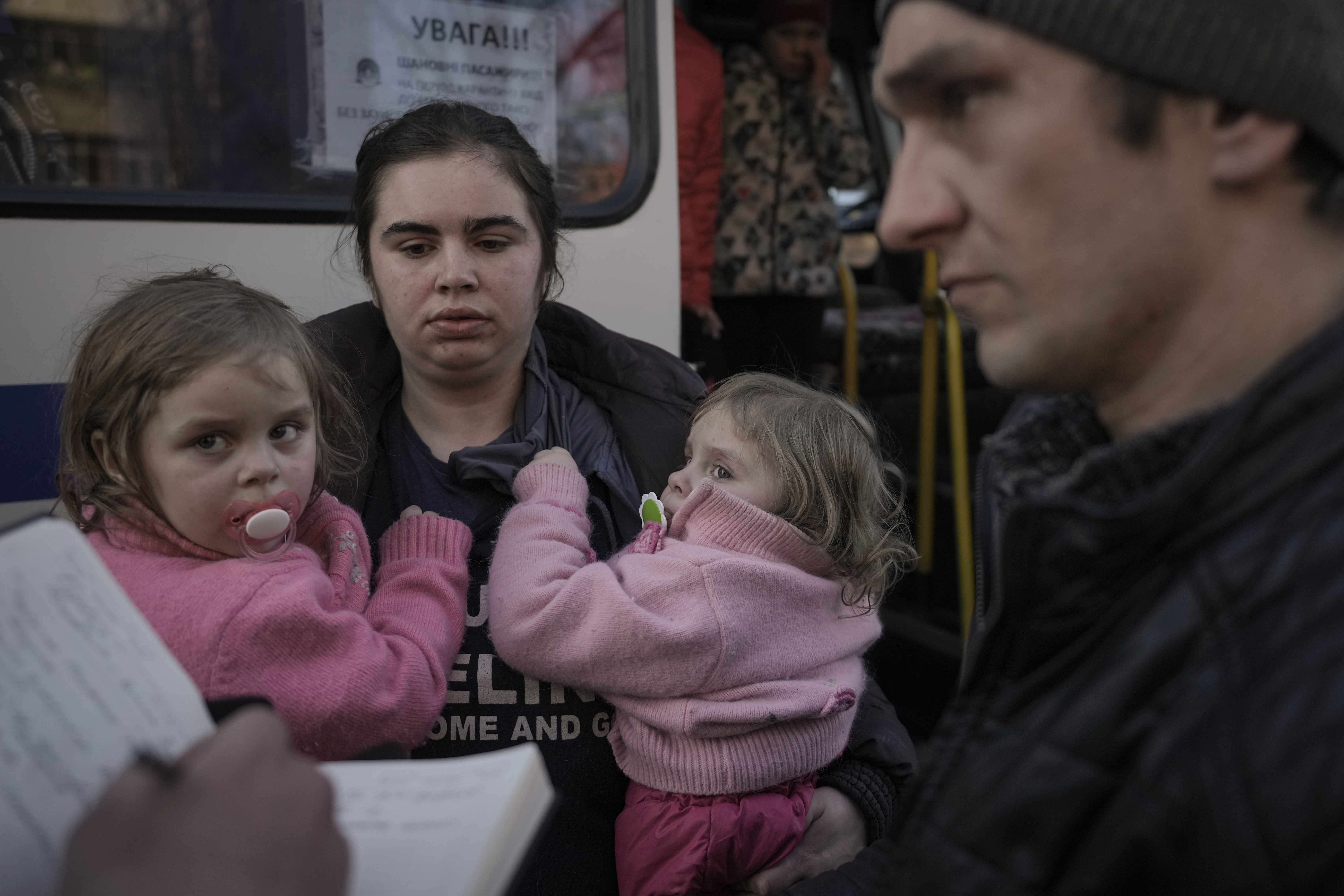 Refugees wait for Ukrainian police to check their papers and belongings in Brovary, Ukraine