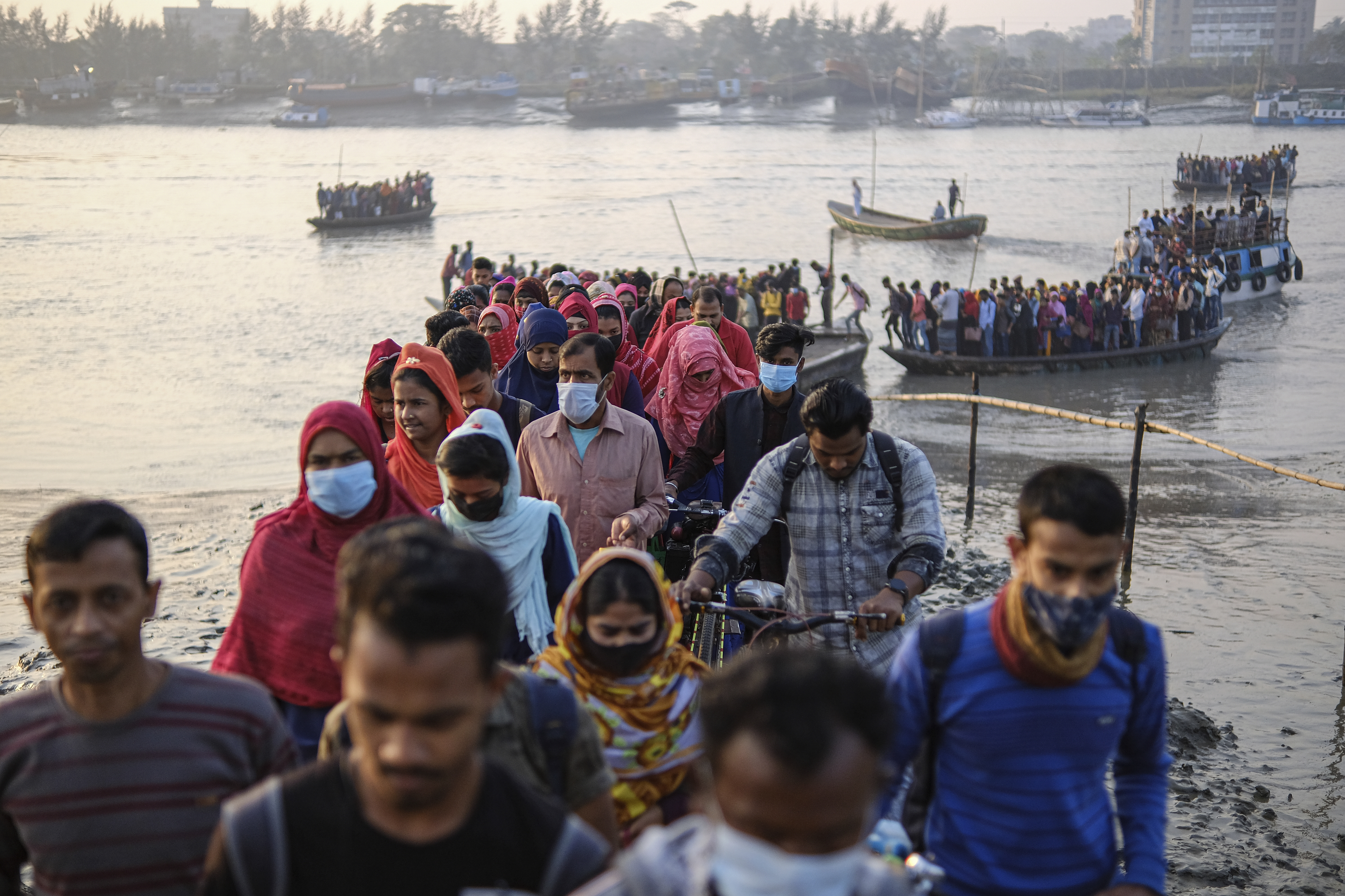 Workers walk to work at an export processing zone early in the morning after crossing the Mongla river in Mongla