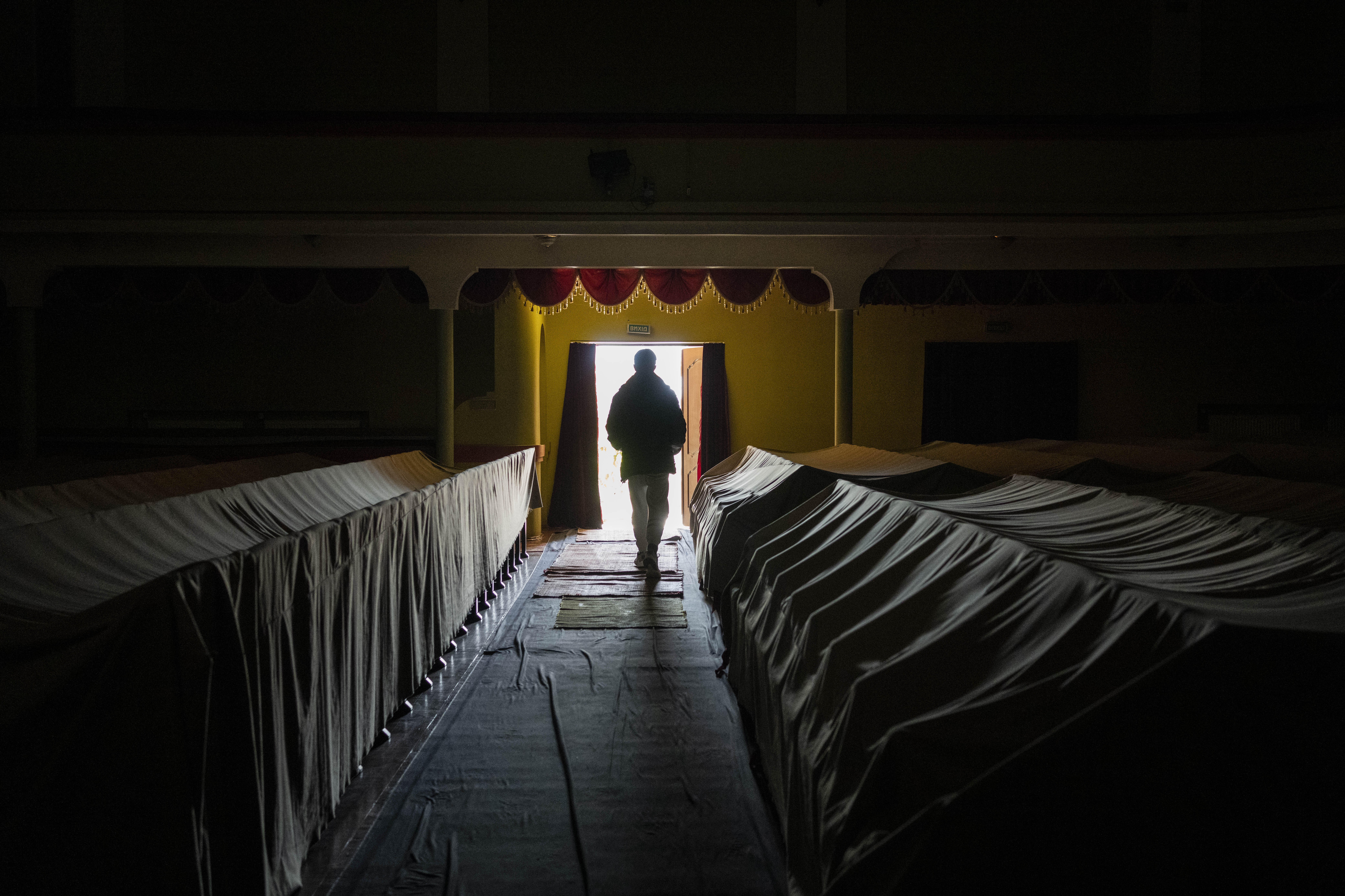 A volunteer walks trhough the audience rows of a theatre in the city of Drohobych
