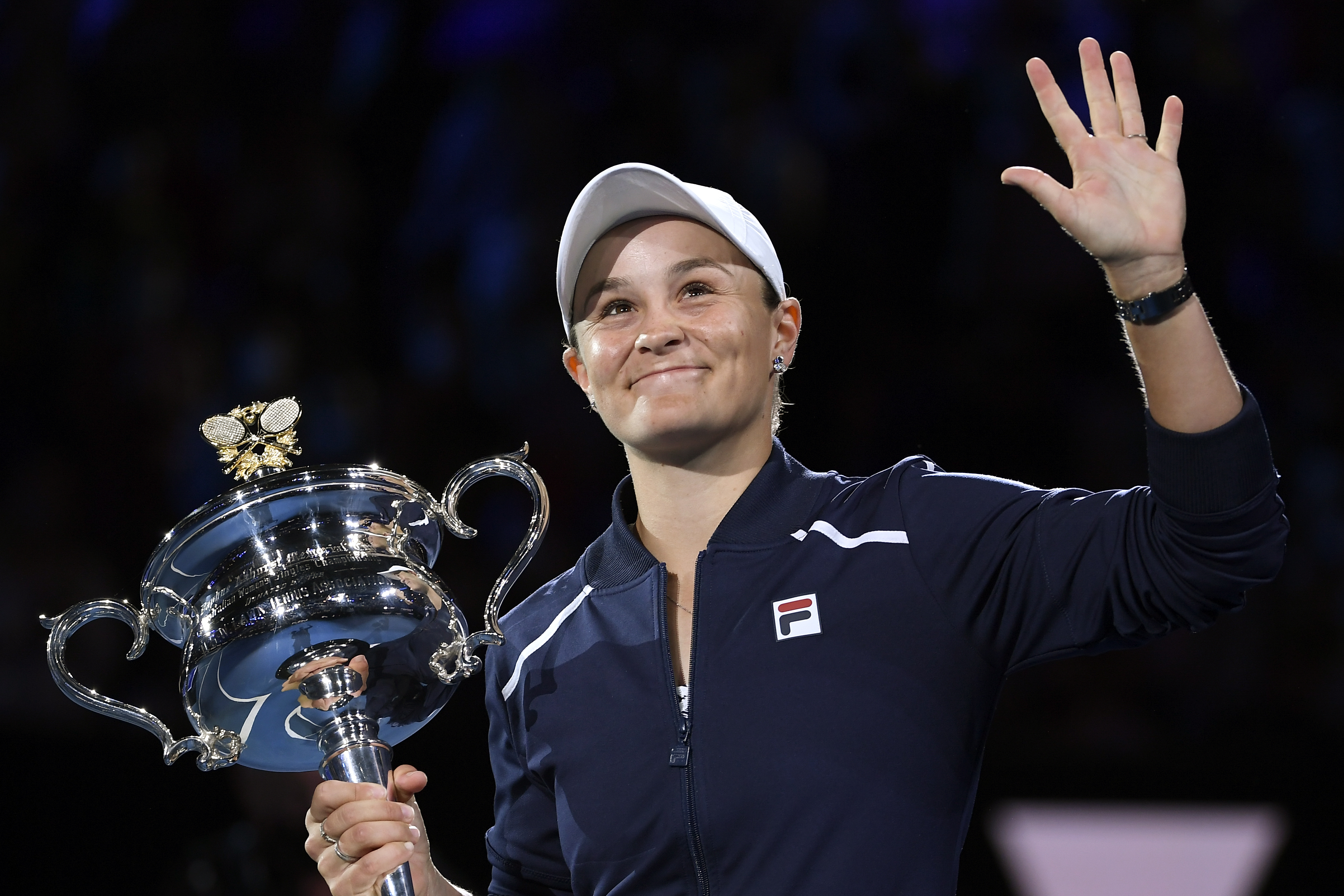 Ash Barty, who has announced her retirement at 25, waves to the crowd as she receives the Australia Open trophy