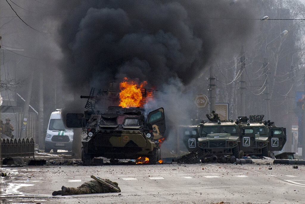 A Russian armored personnel carrier burns amid damaged and abandoned light utility vehicles after fighting in Kharkiv, Ukraine.