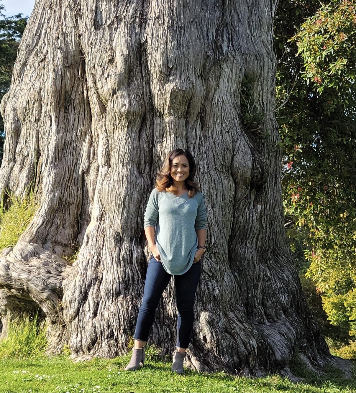 A photo of Ny Nourn standing in front of a large tree.