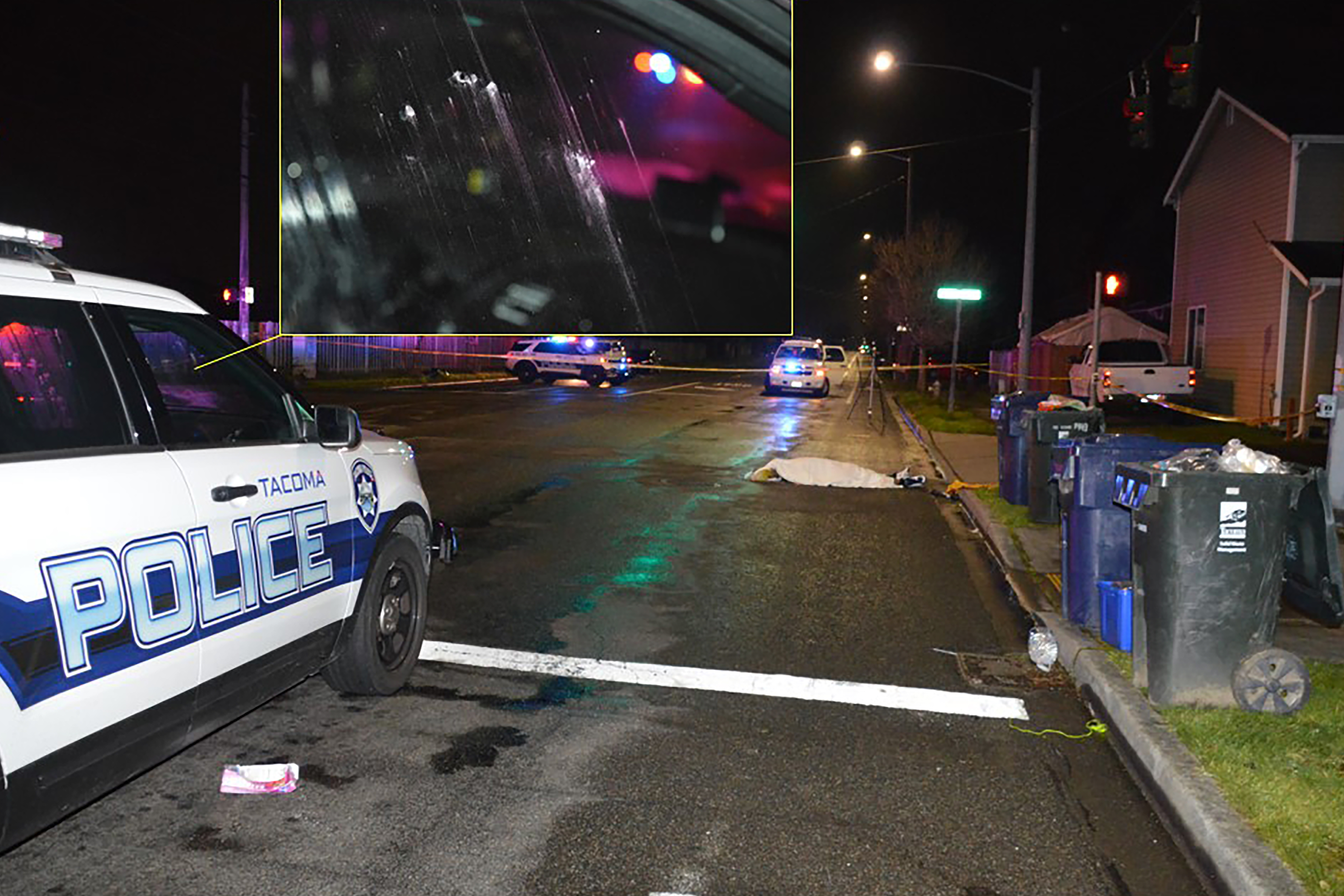 A smashed box of donuts is seen beside a police vehicle close to the covered body of Manuel Ellis