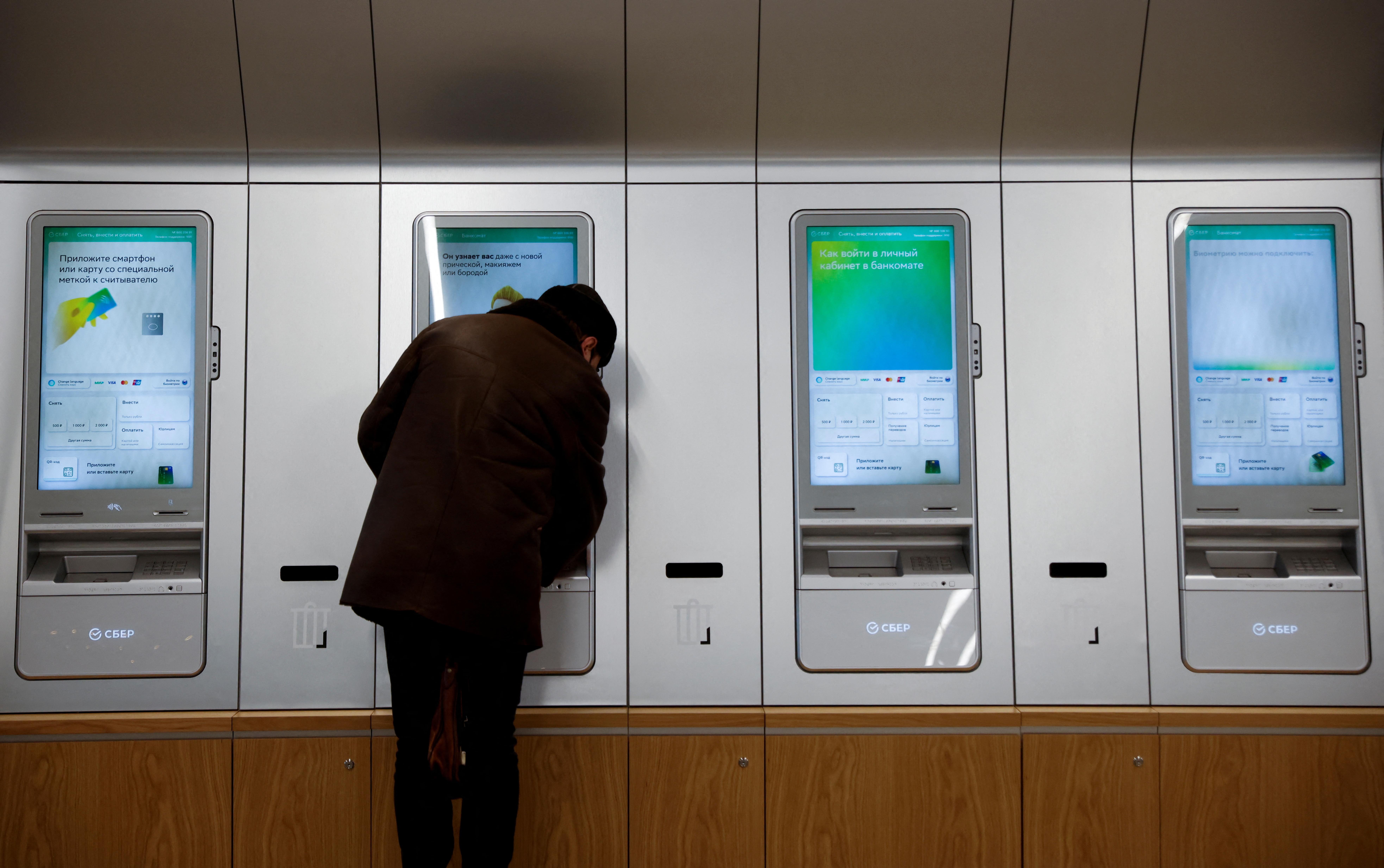 A man uses an ATM machine in an office of the Russian largest lender Sberbank in Moscow, Russia