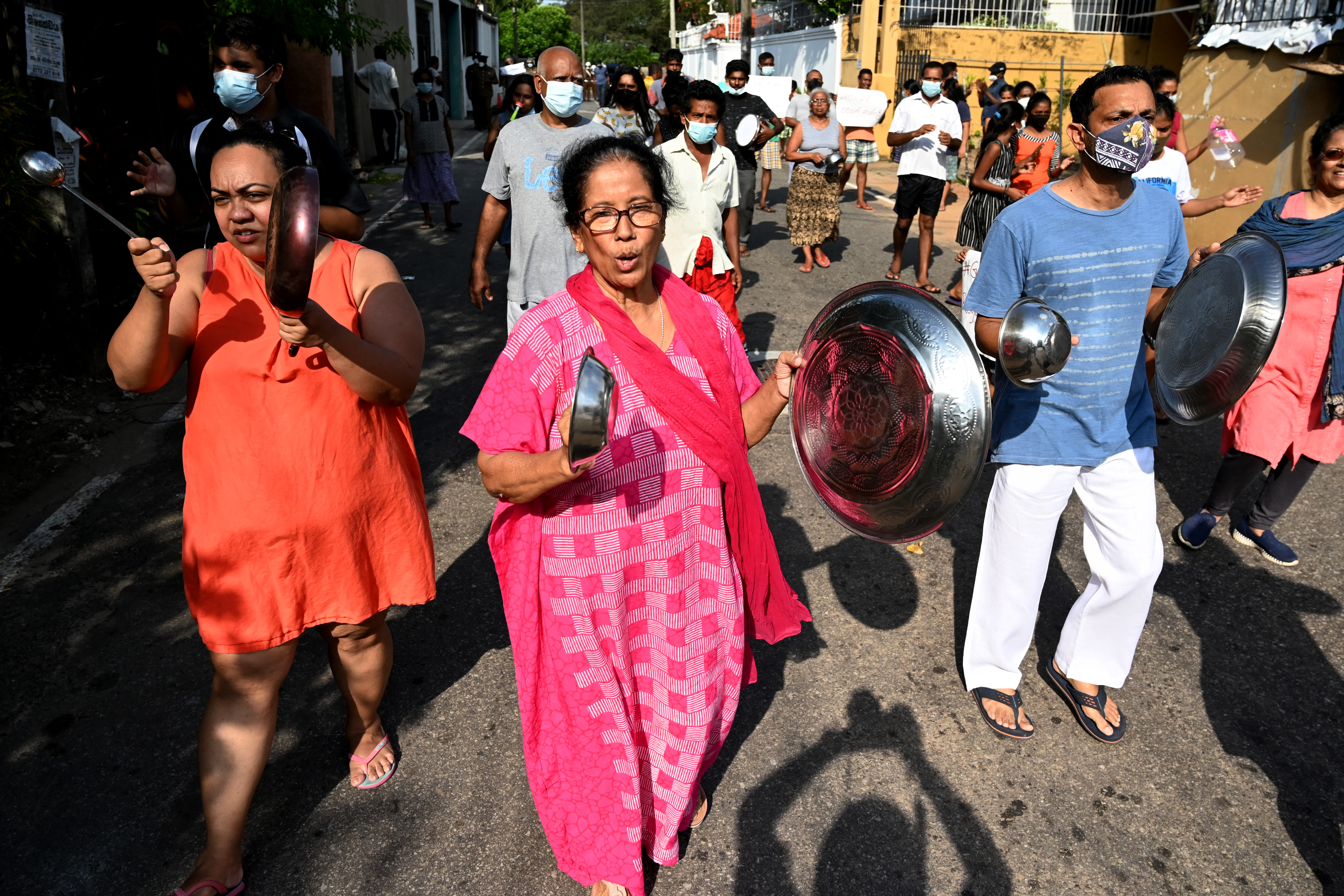 Protestors beat utensils as a sign of protest during a march against the surge in prices and shortage of fuel and other essential commodities in Colombo