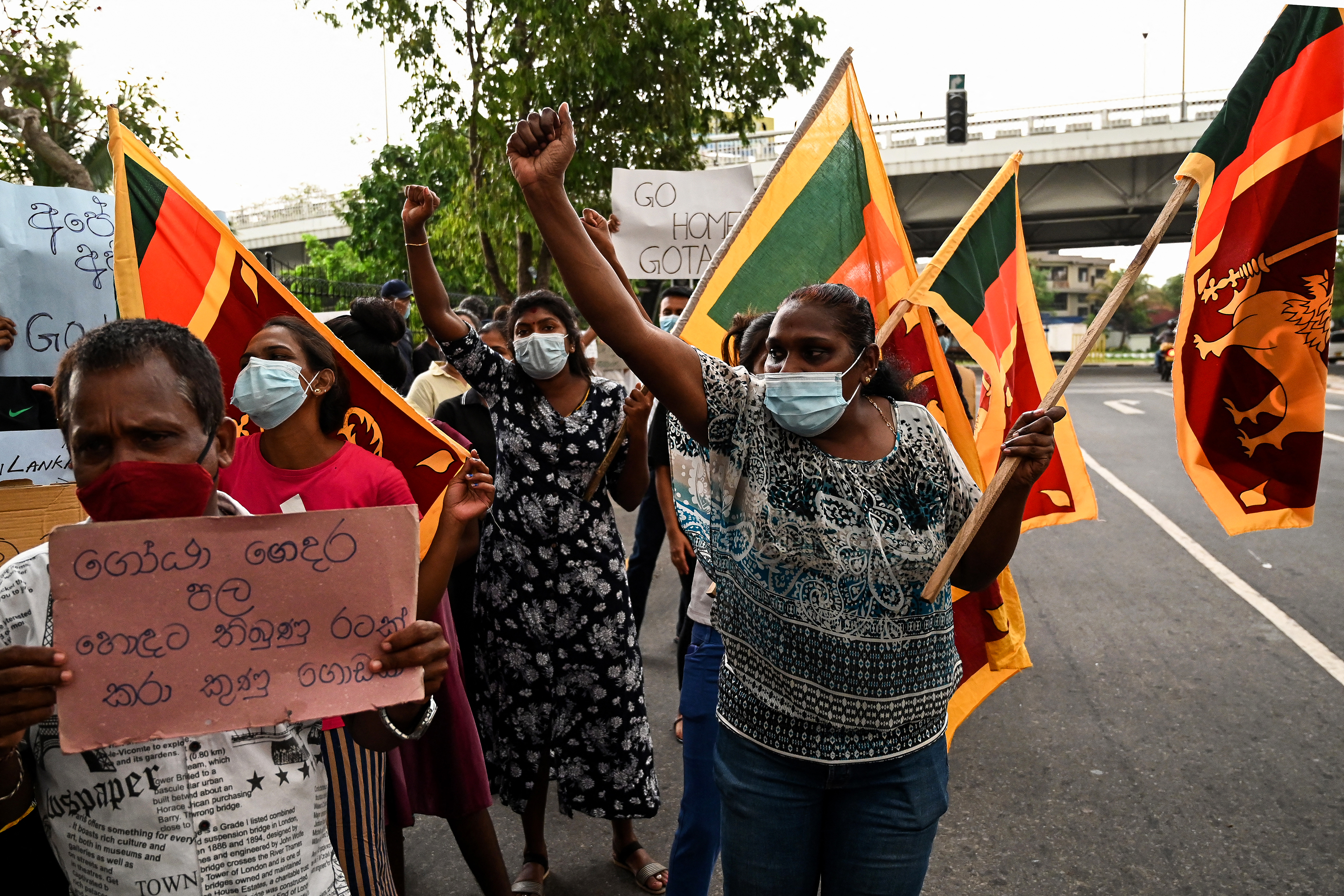 Protestors hold banners and placards during a demonstration against the surge in prices and shortage of fuel and other essential commodities in Colombo