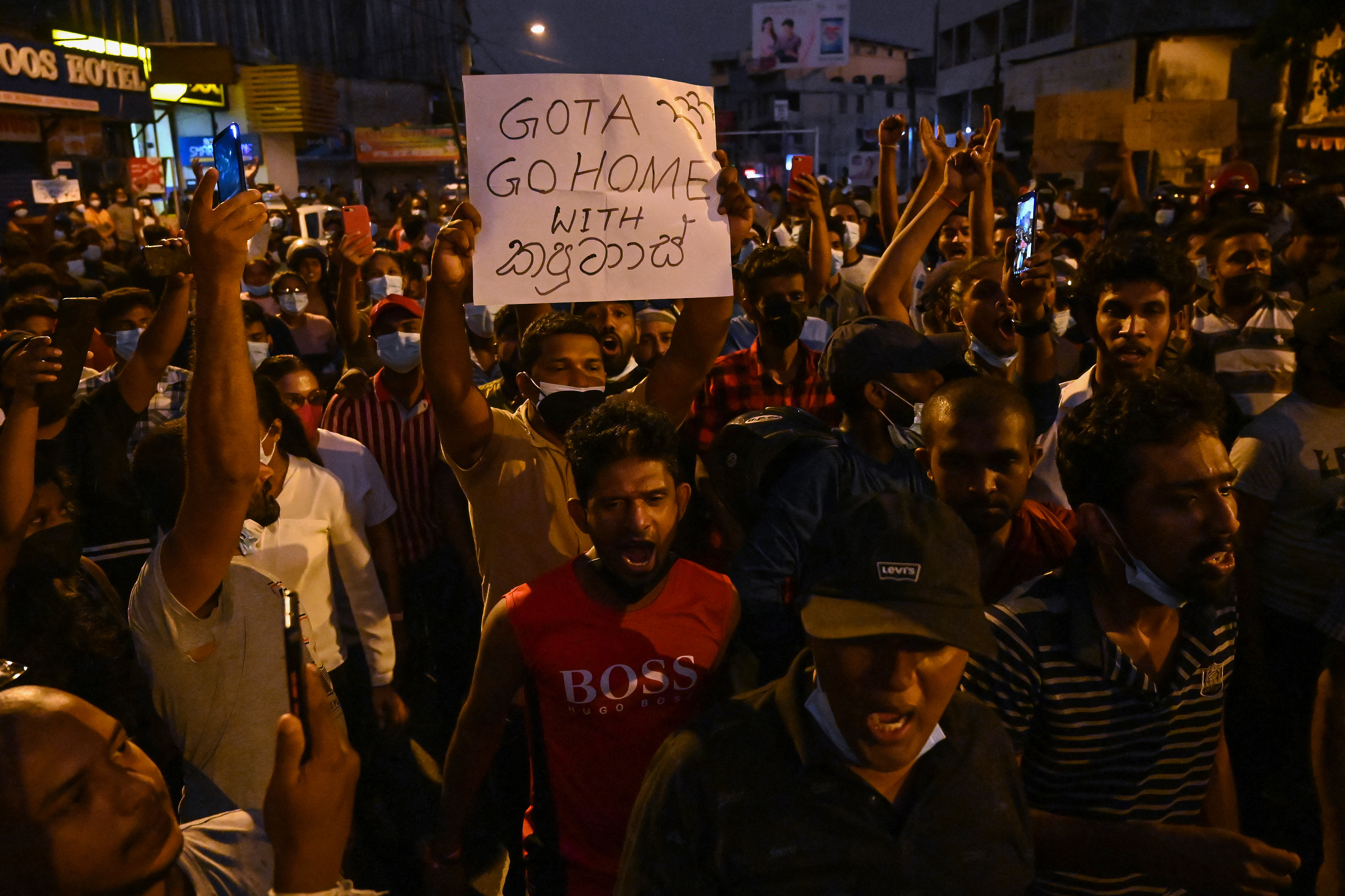 Protestors hold banners and placards during a demonstration against the surge in prices and shortage of fuel and other essential commodities in Colombo