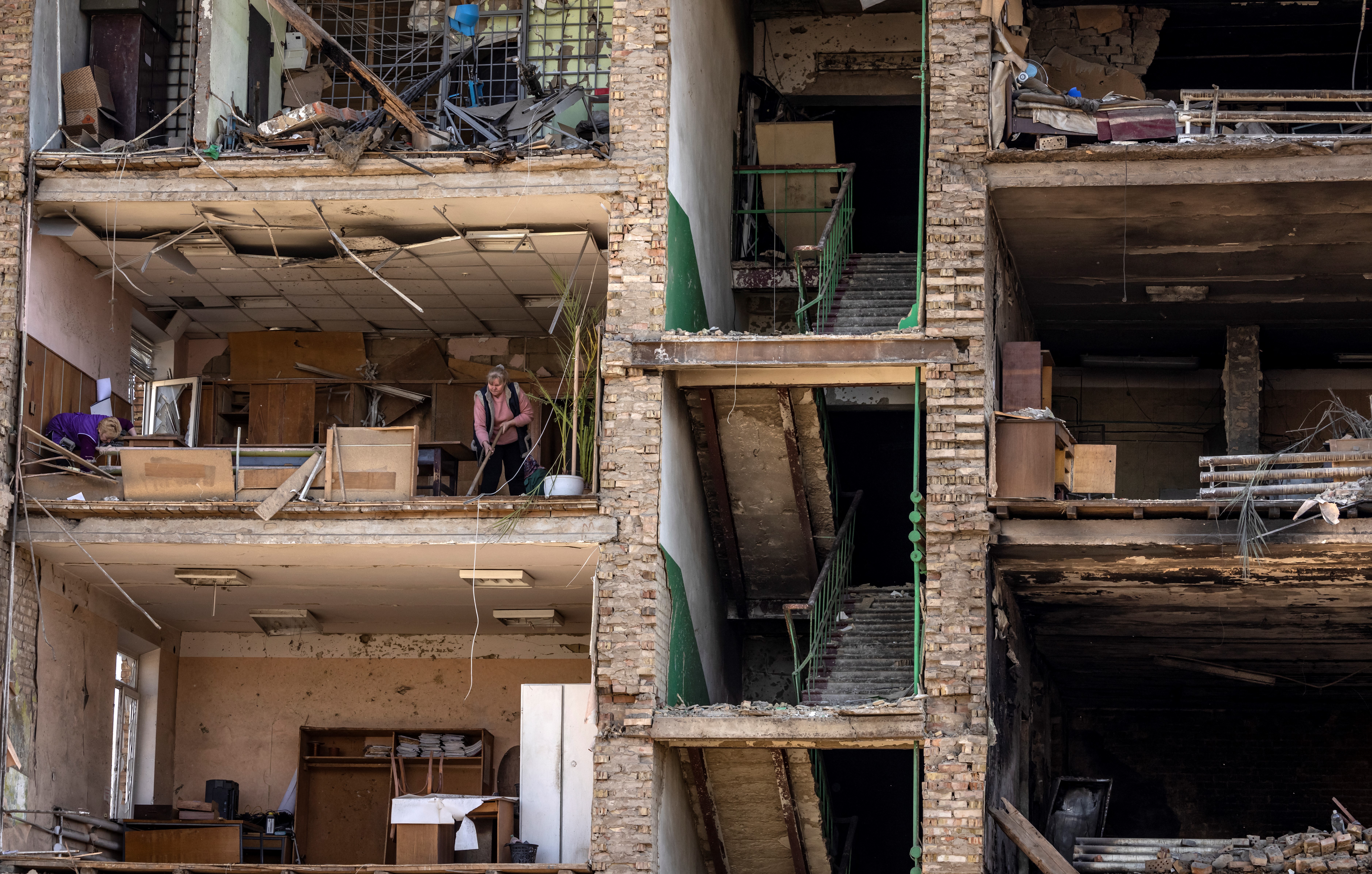 Women clean in a building with a collapsed facade at the Vizar company military-industrial complex