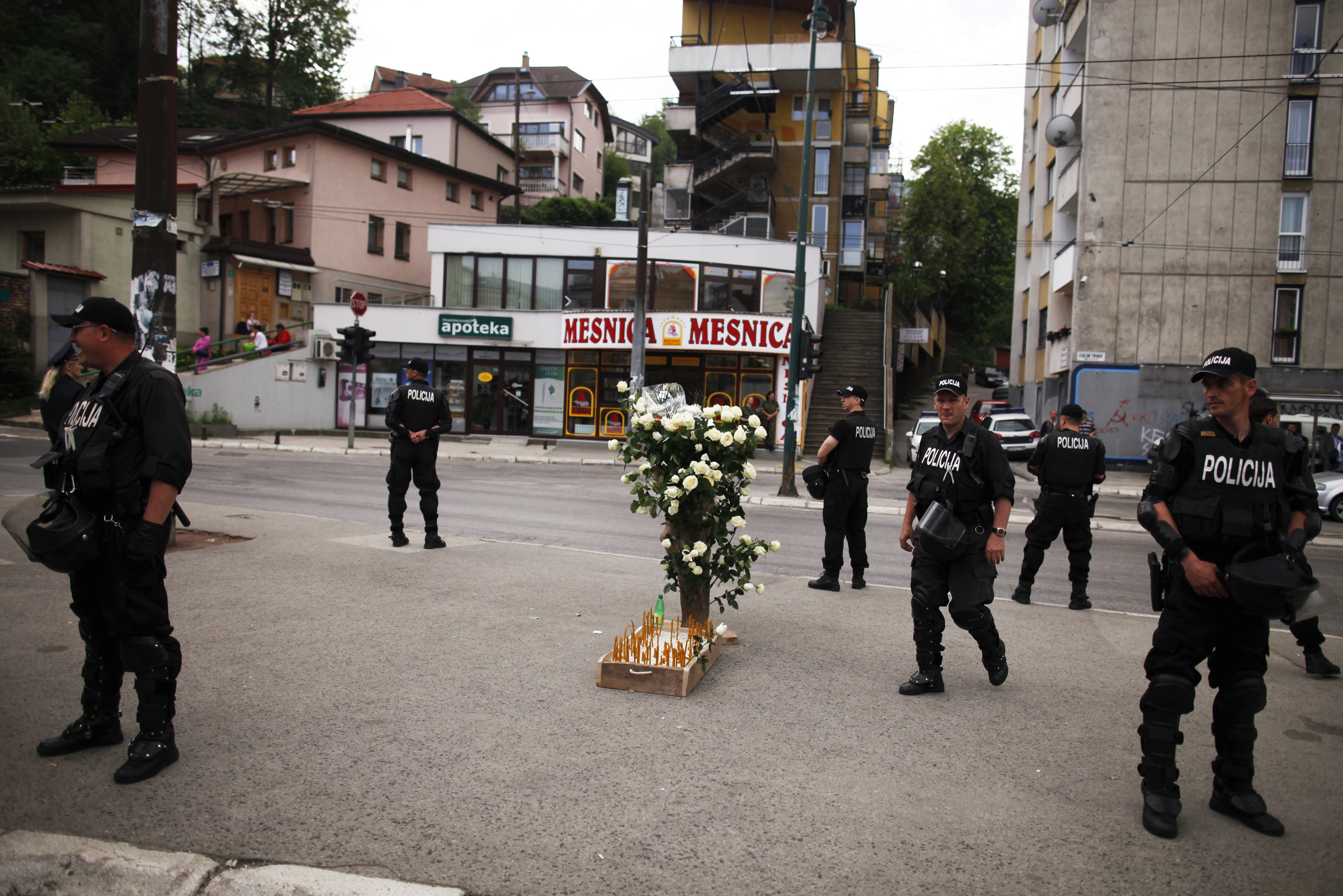 Members of the special police take their positions and keep watch over flowers and candles placed after a commemoration in Dobrovoljacka street in Sarajevo, May 3, 2012