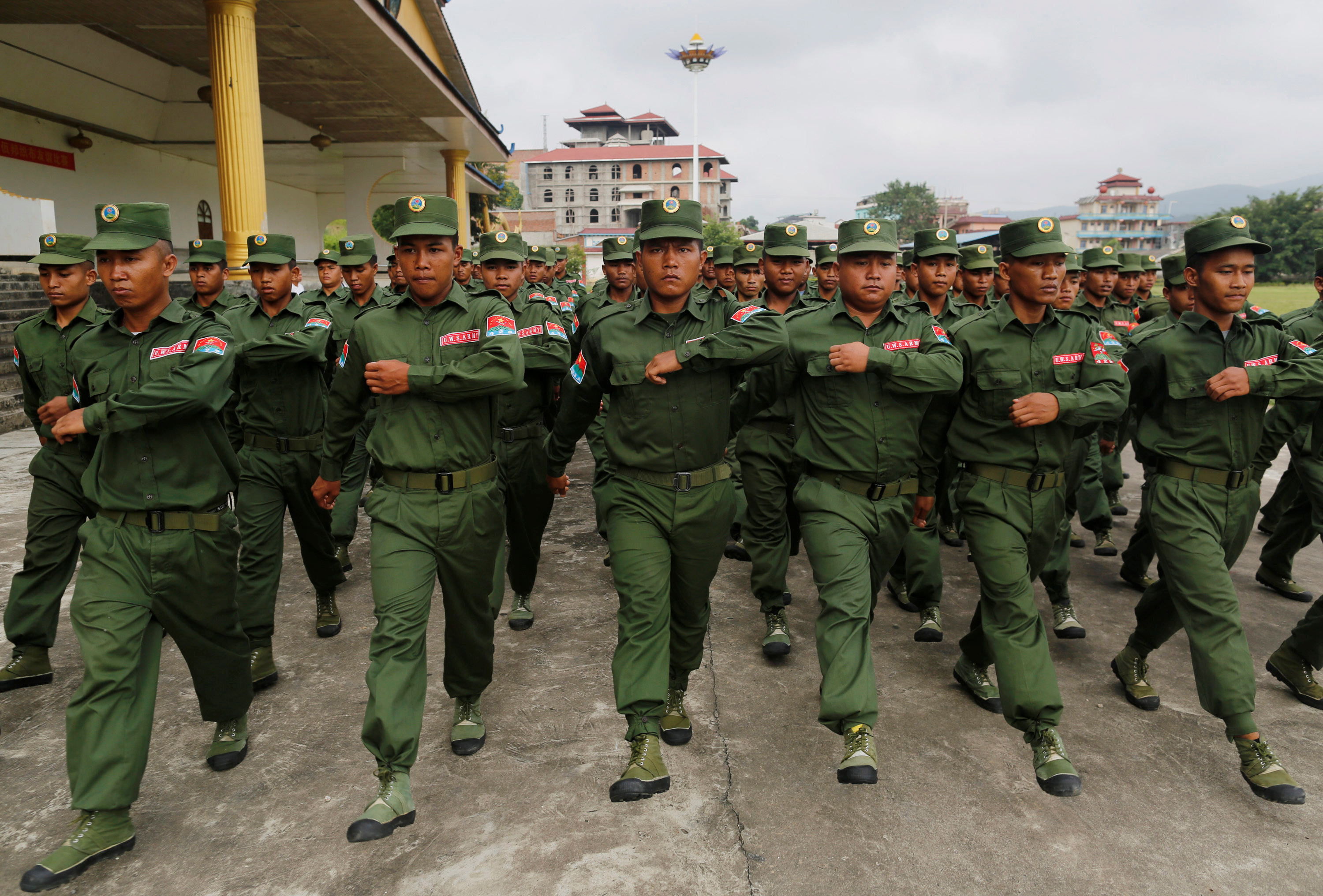 United Wa State Army troops in green uniforms march in formation in the town of Pansang, Myanmar.