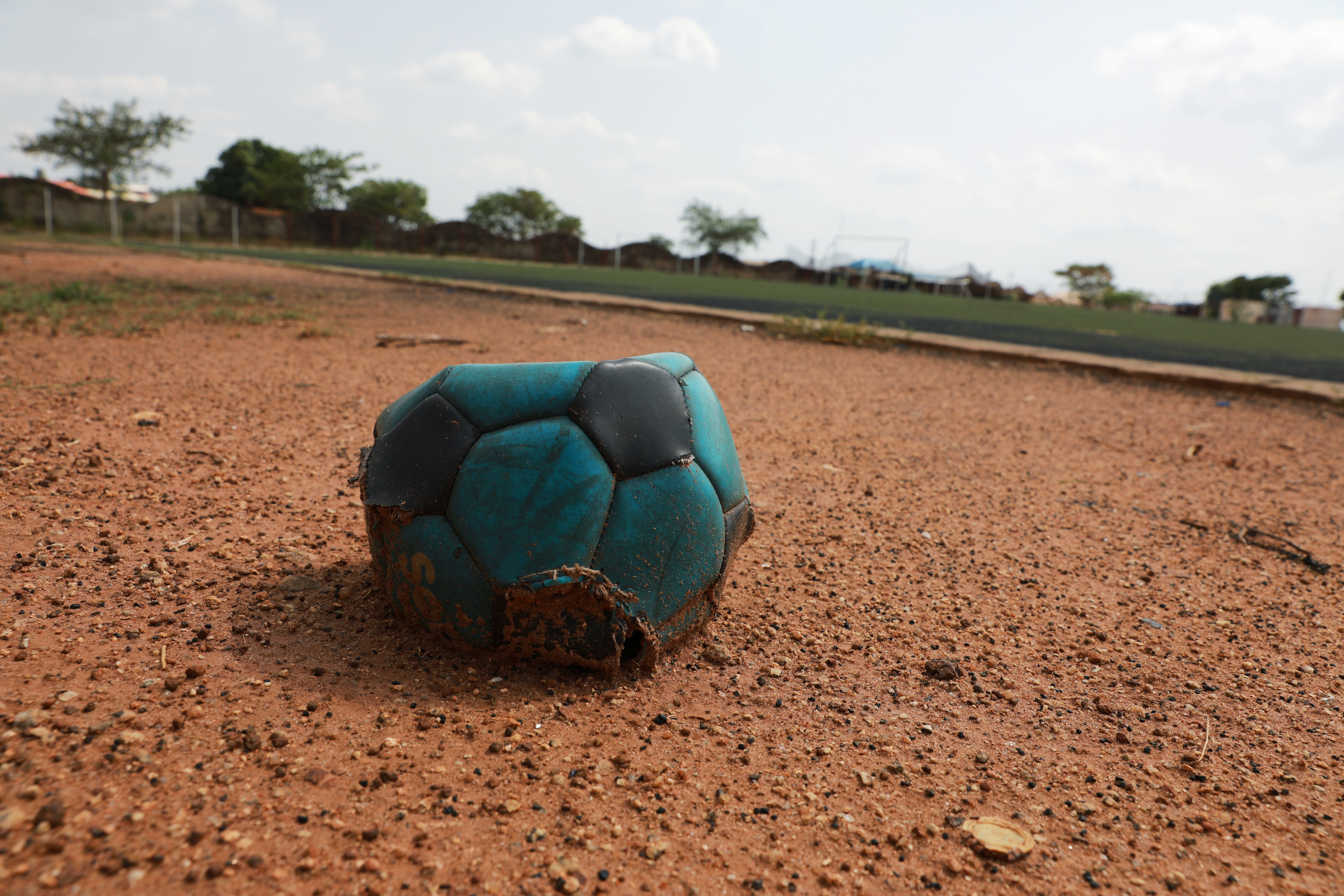A deflated football is seen on the sidelines of a football field in Nigeria