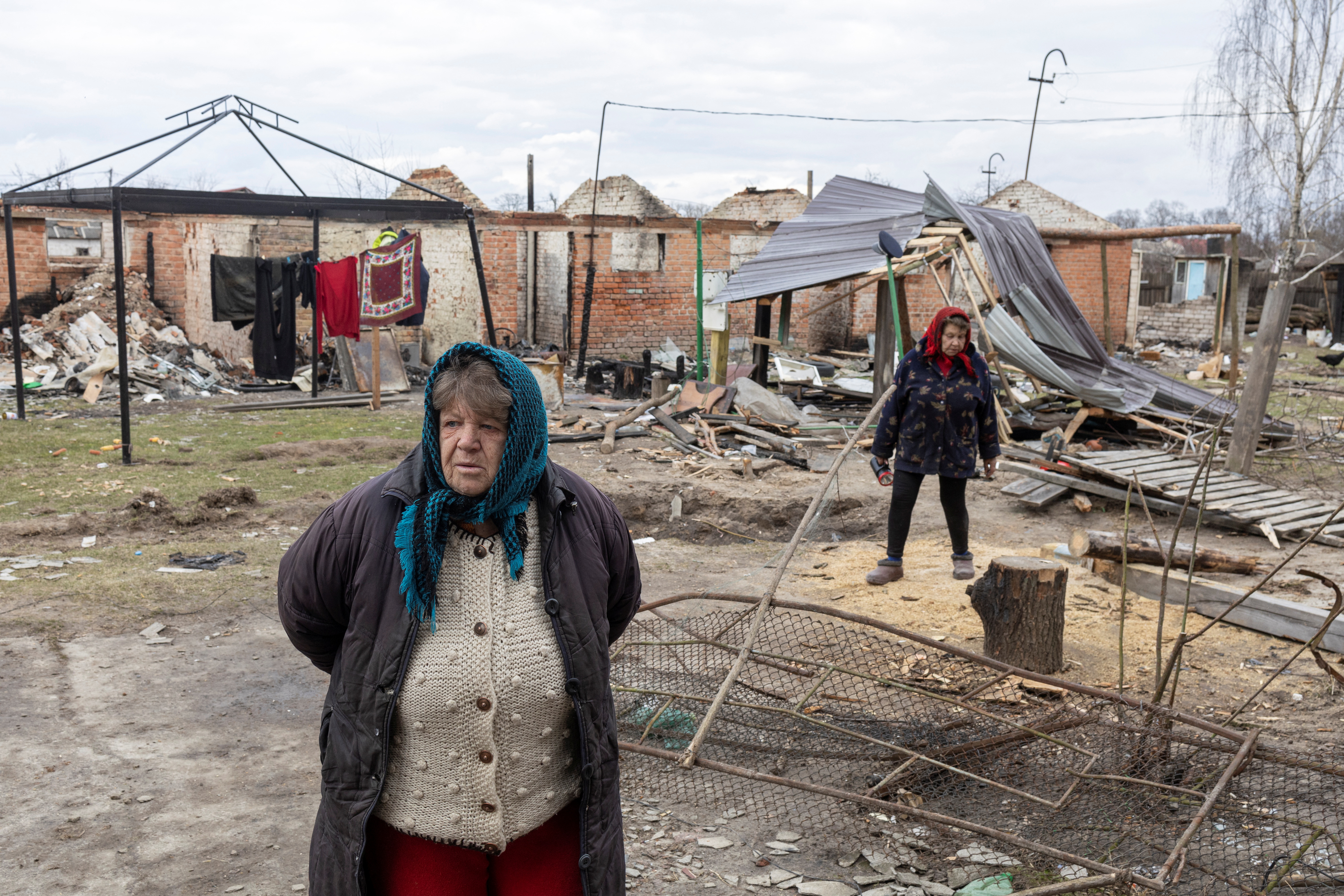 Hanna Khlystun stands amongst destroyed in the village of Yahidne