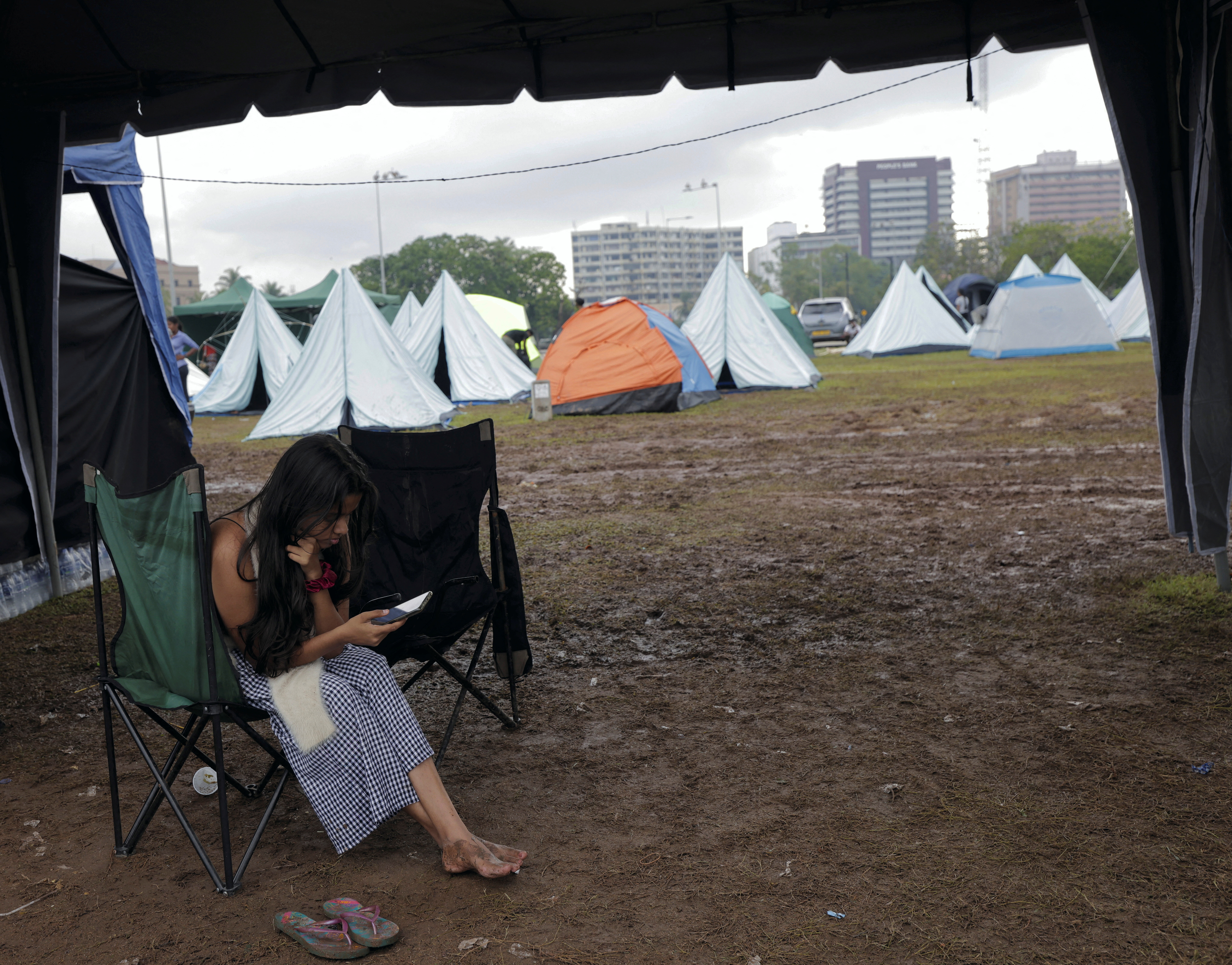 A demonstrator checks her mobile phone inside a tent at a protest are