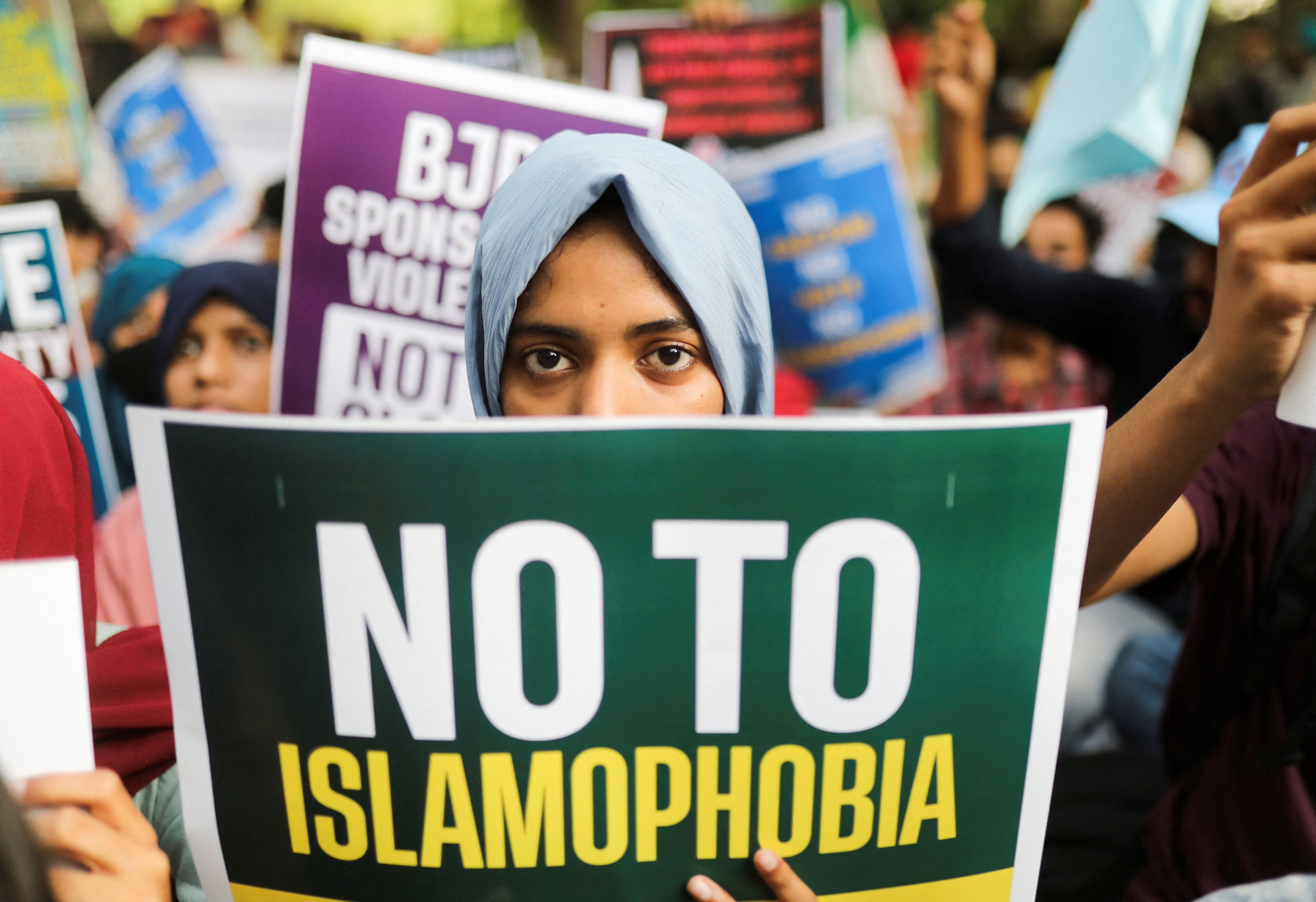 Young women holds a sign that reads "no to islamophobia".