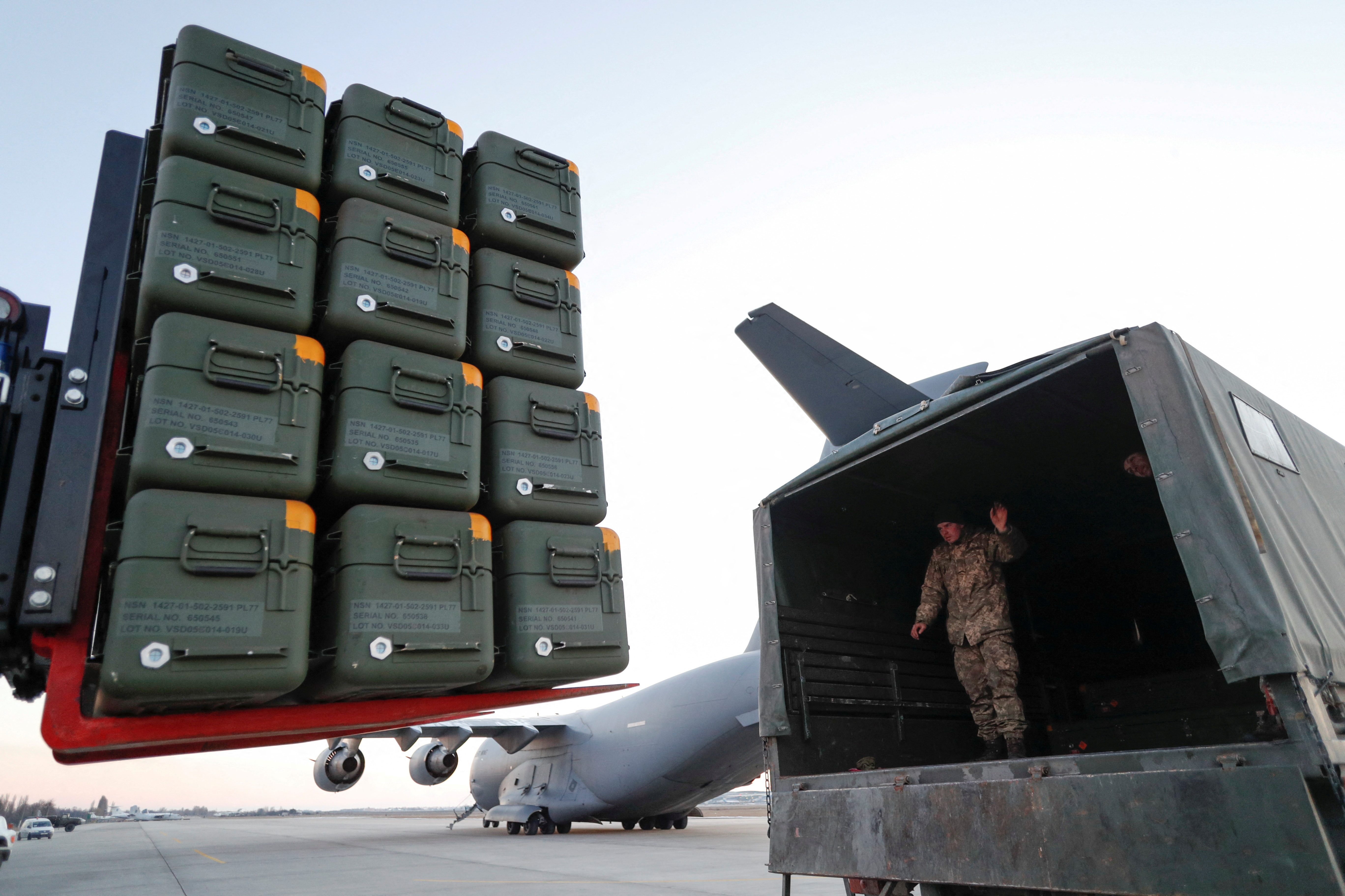 Military aid is seen being unloaded at an airport in Kyiv