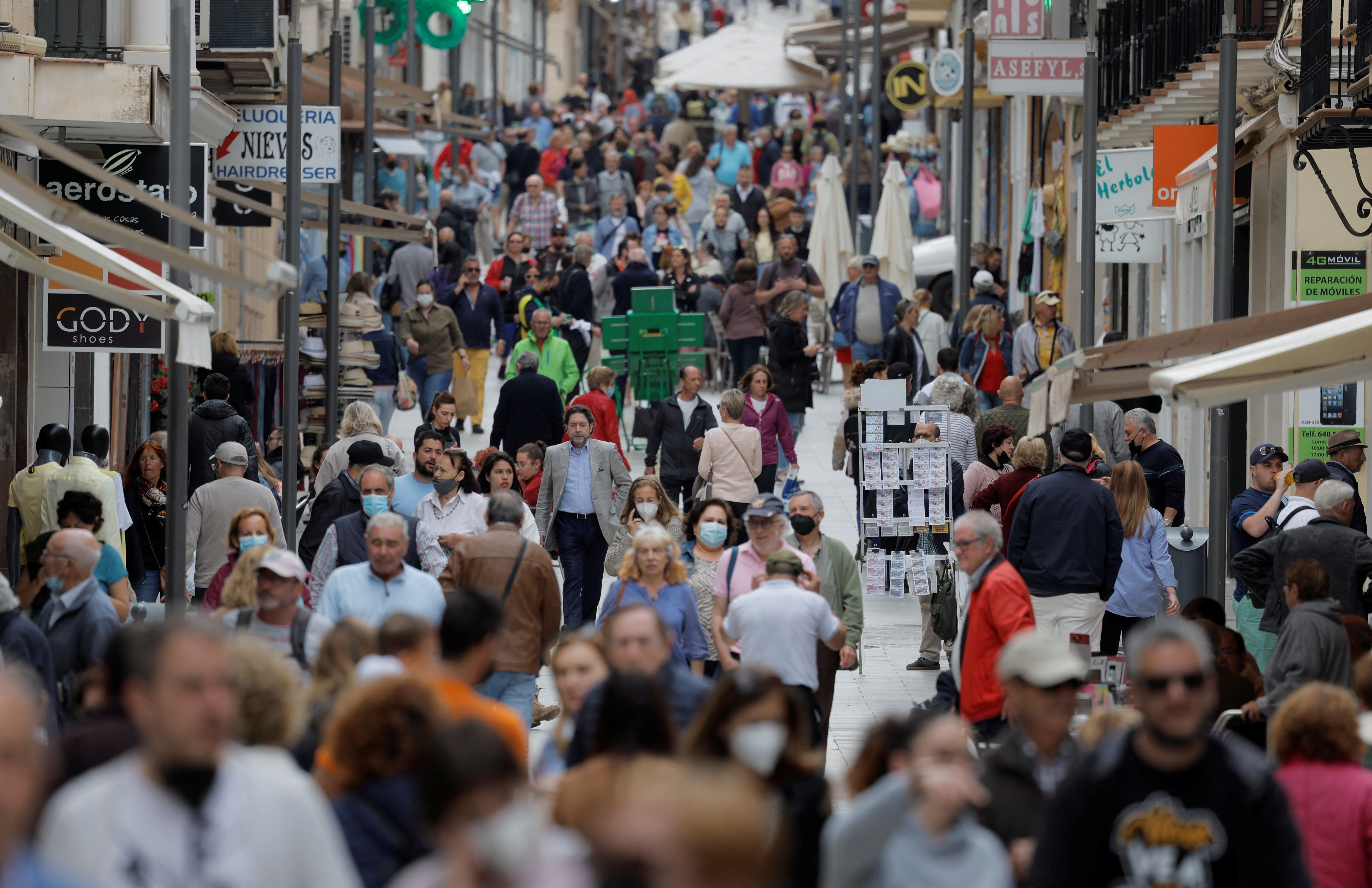 People walk along La Bola shopping street in Ronda, southern Spain