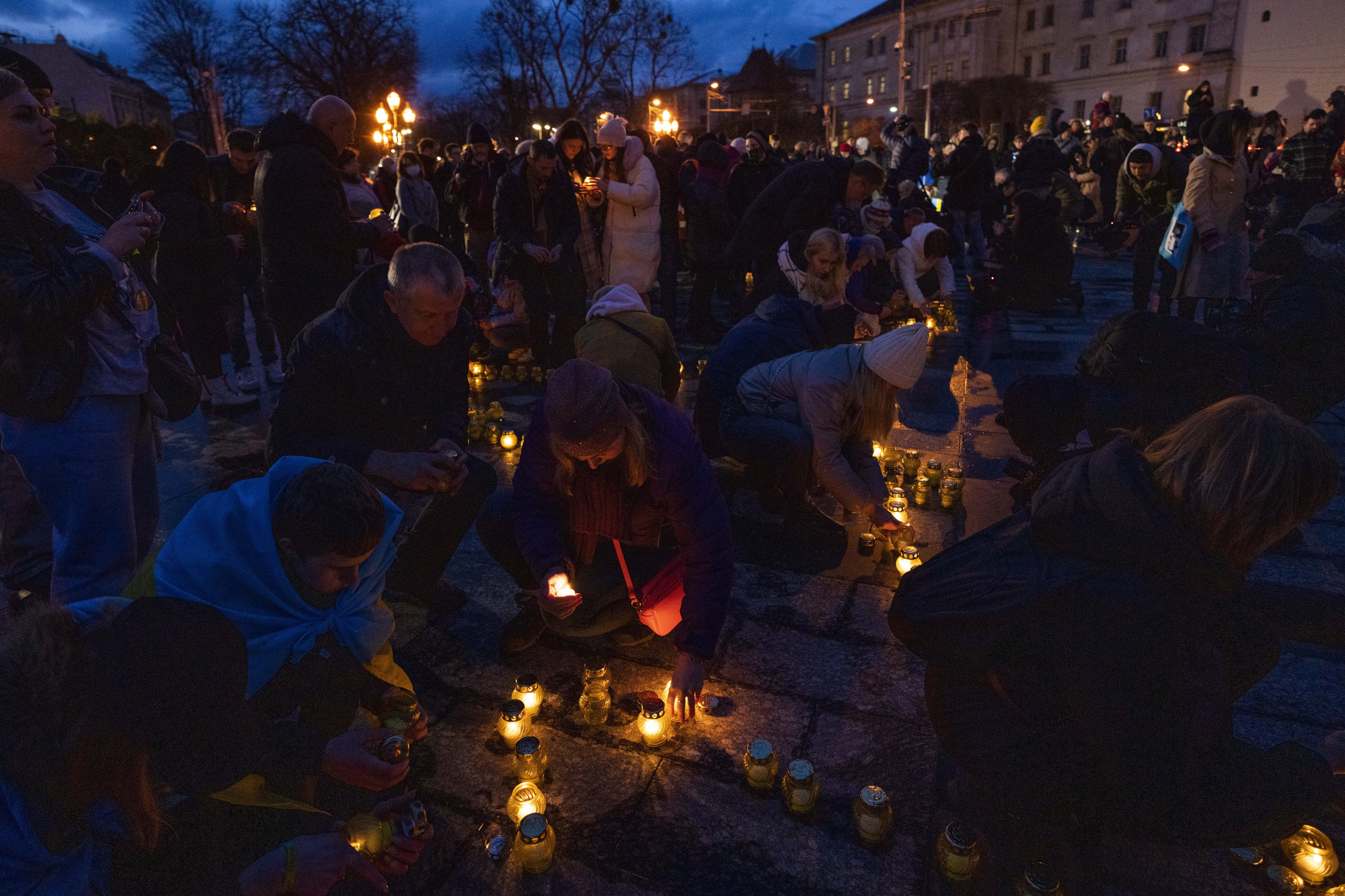 People light candles forming the shape of Ukraine's map, in memory of lost lives, in front of the Taras Shevchenko monument, in Lviv, western Ukraine, 