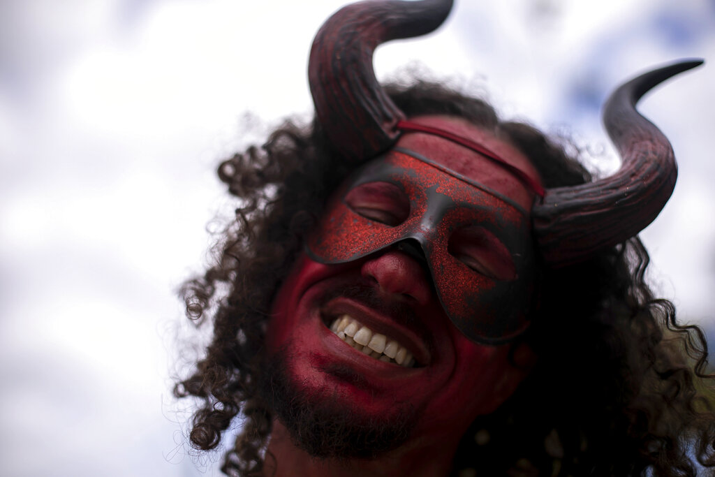 A masked reveler dances in the "Cordão do Boitata" parade during the traditional black culture carnival event "Feira das Yabas" in the suburbs of Rio de Janeiro, Brazil.