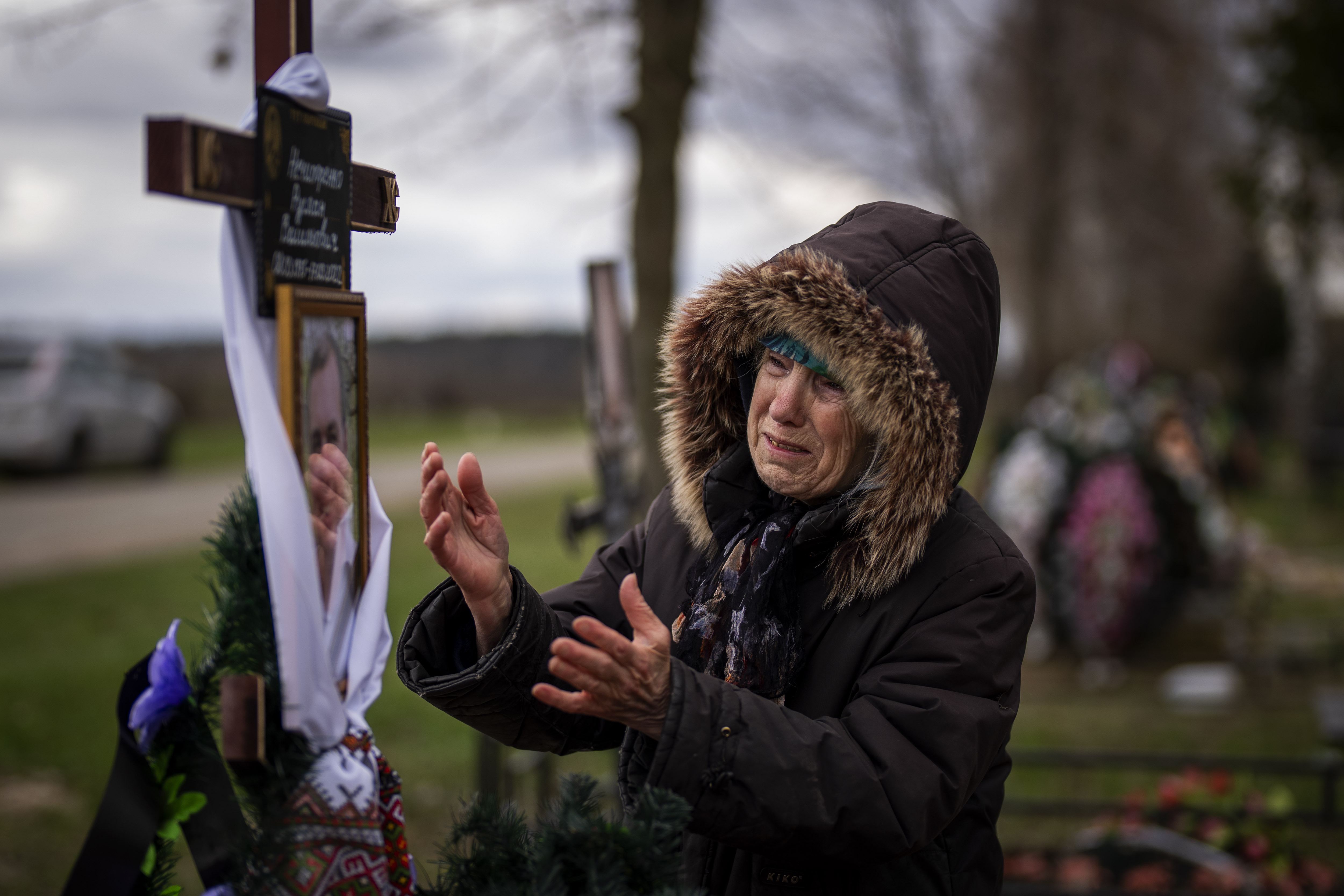 Valentyna Nechyporenko, 77, mourns at the grave of her 47-year-old son Ruslan, during his funeral at the cemetery in Bucha, on the outskirts of Kyiv, Ukraine.