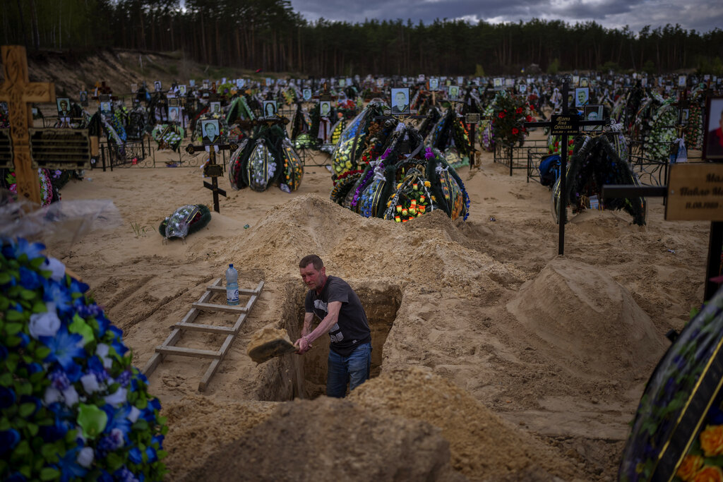 Gravedigger Alexander digs a grave at the cemetery in Irpin on the outskirts of Kyiv.